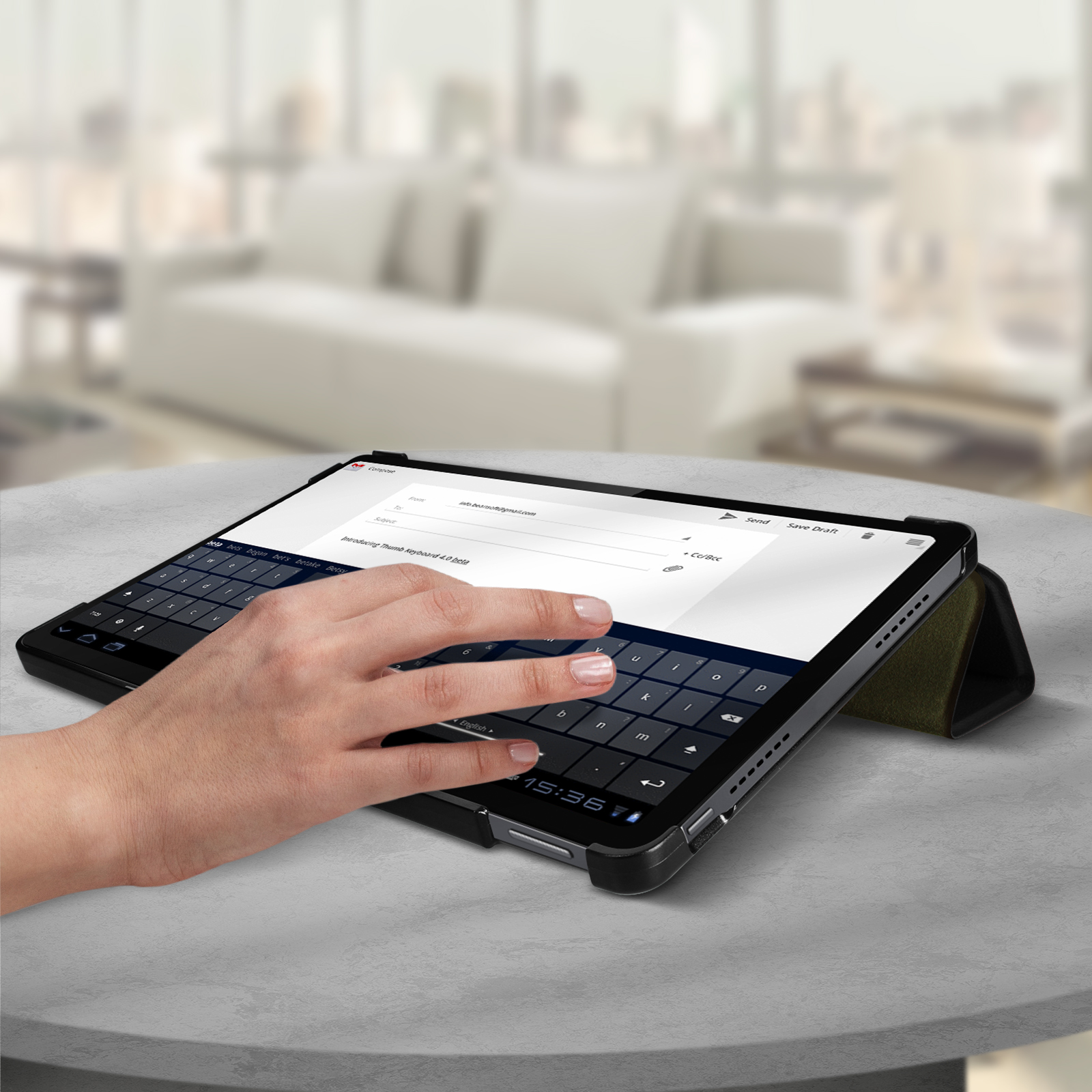 Una mano che usa un tablet con tastiera su un tavolo.