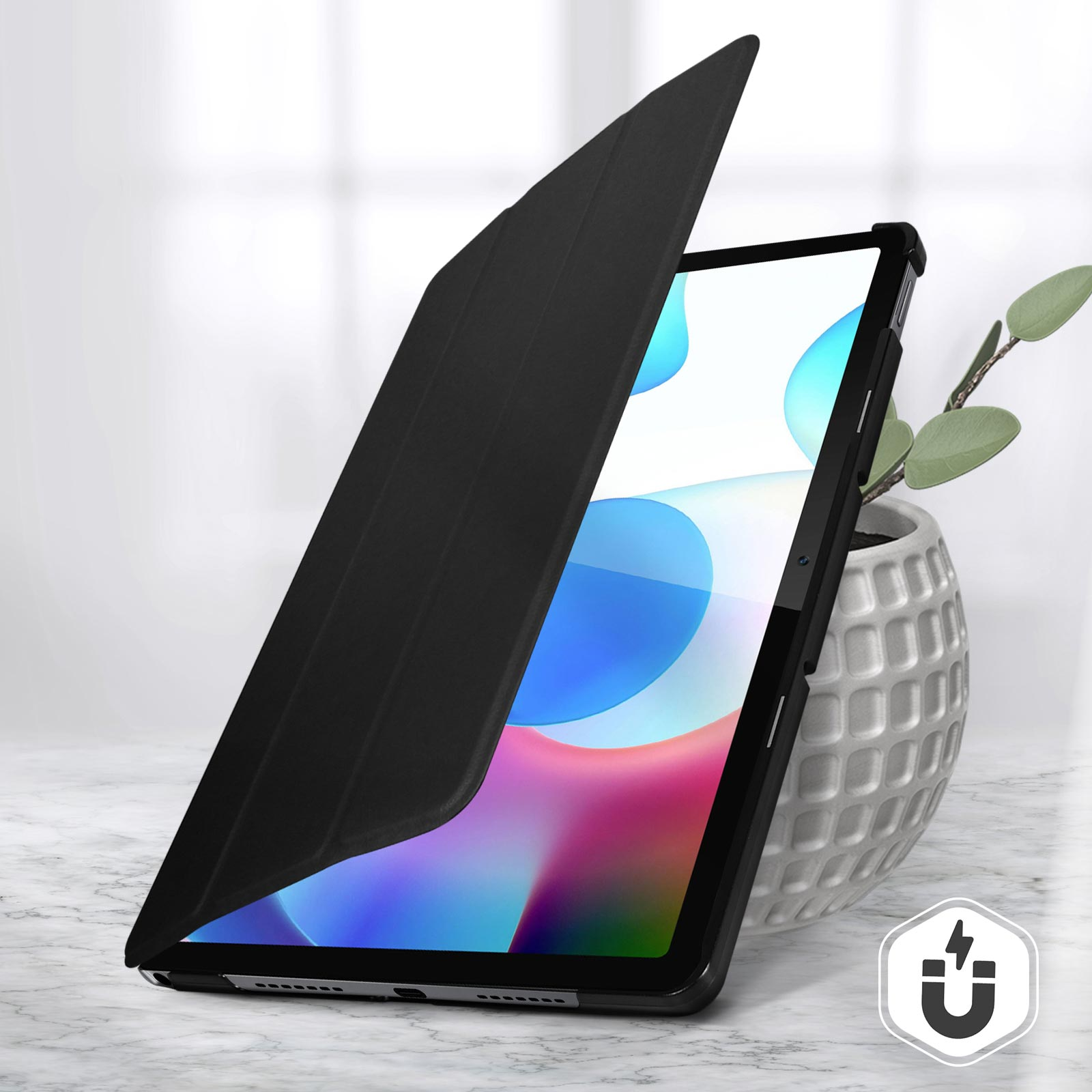 Tablet nero in custodia, parzialmente aperto. Pianta in vaso bianco.