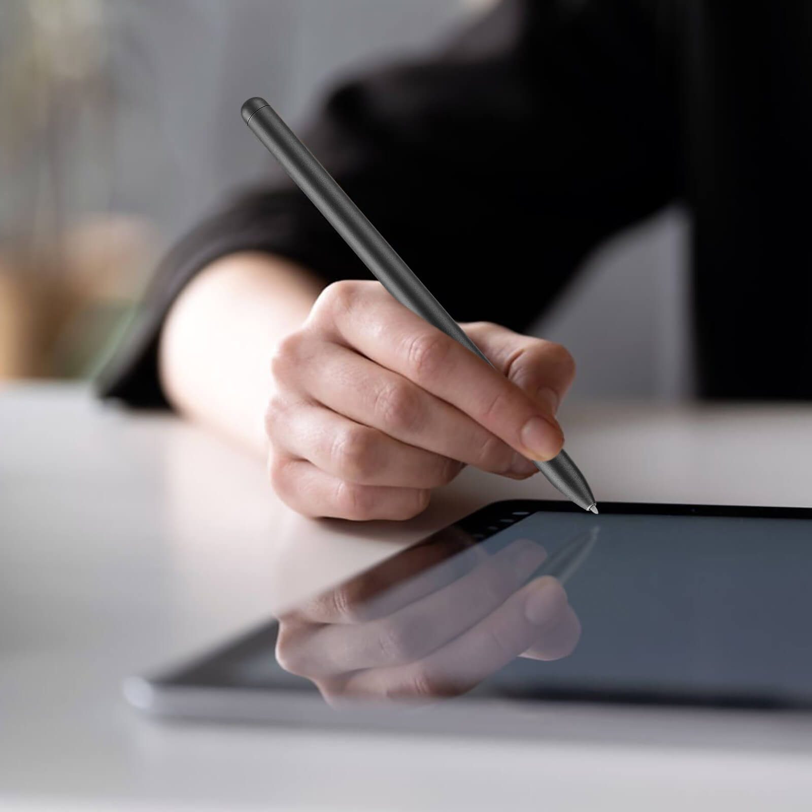 Dłoń używa rysika na ekranie tabletu. Rysik jest czarny.