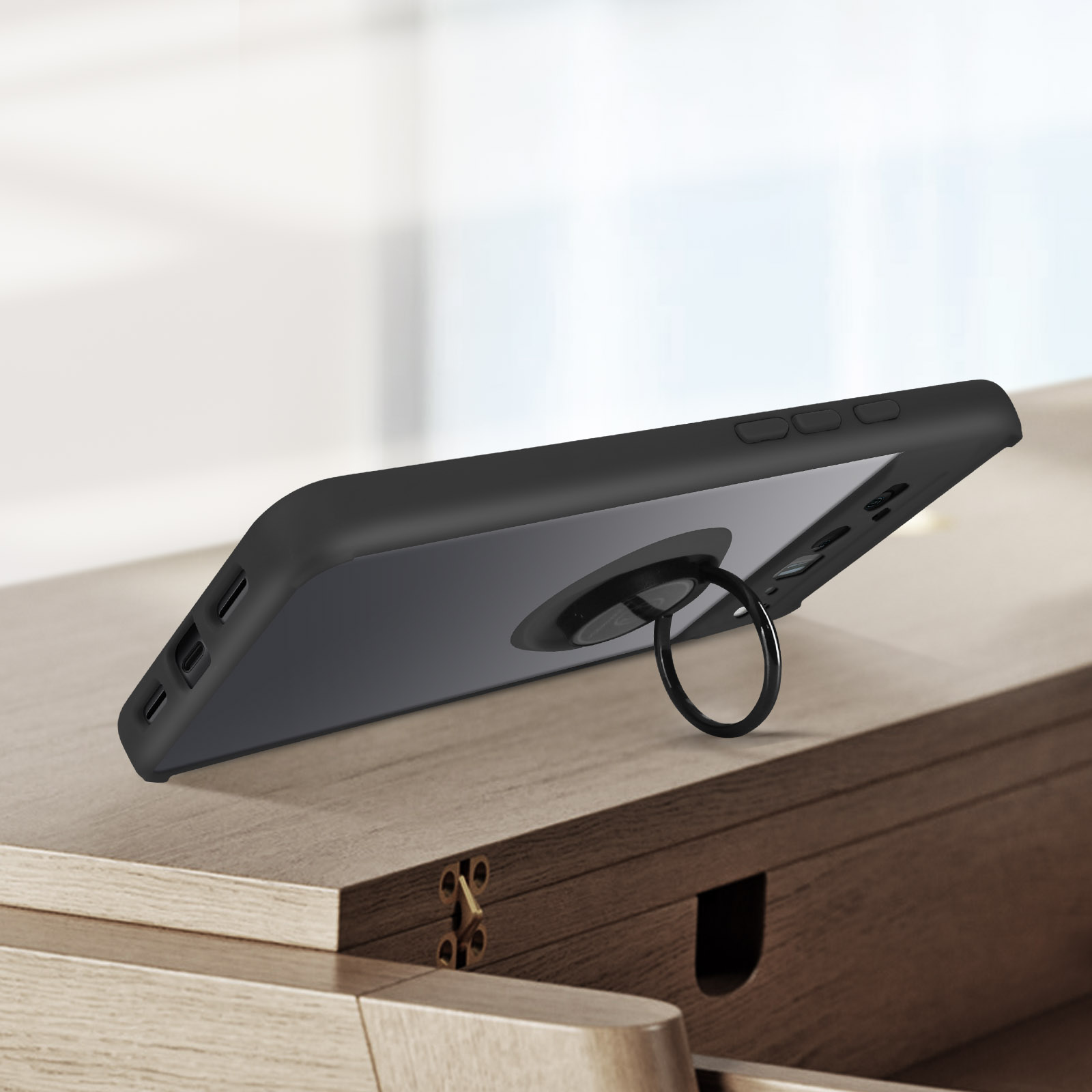 Zwarte telefoon met zwarte ringhouder case, op een houten oppervlak.