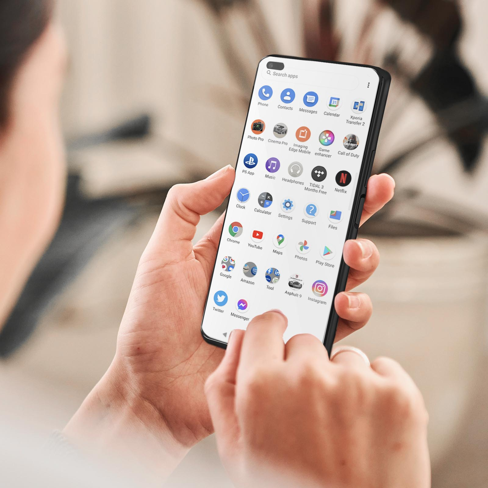 Mano che tiene in mano uno smartphone. Il telefono visualizza molte app. La mano è vicino a uno sfondo sfocato.