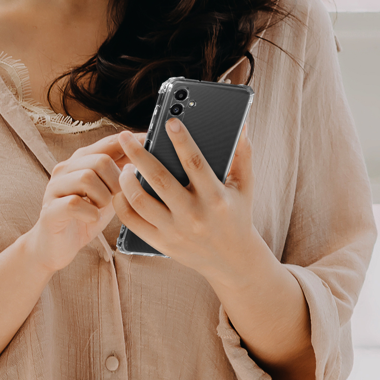 Persona che tiene un telefono in una custodia trasparente.