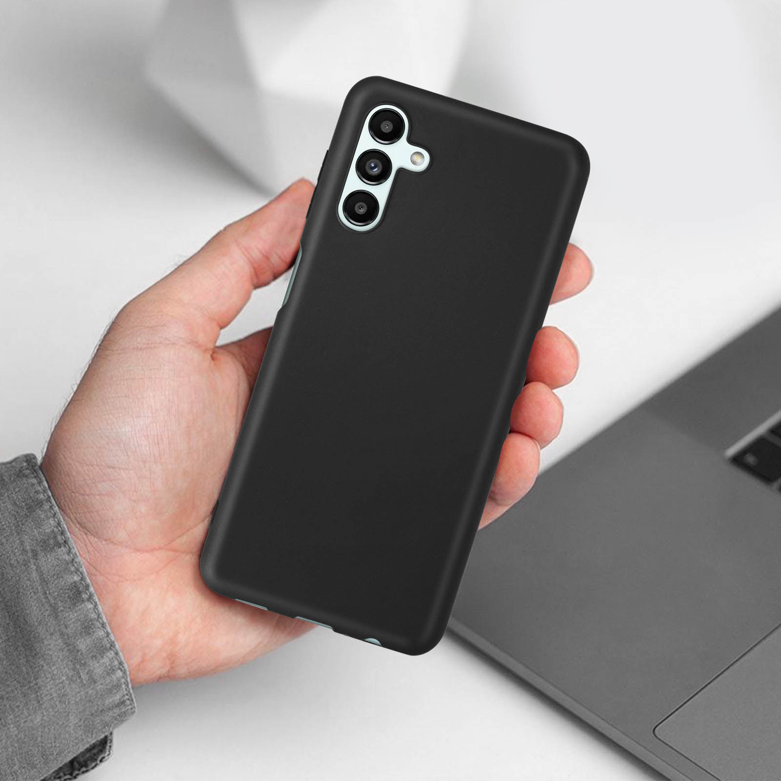 Een hand die een zwarte telefoonhoes vasthoudt. De telefoonhoes heeft een verhoogd gedeelte rond de camera.