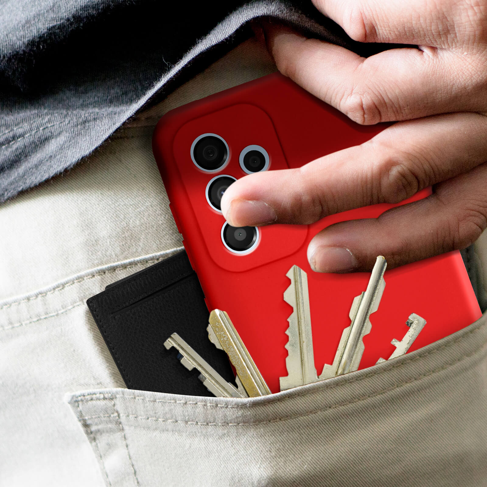 Die Hand einer Person in einer Tasche, die ein rotes Telefon und Schlüssel hält. Ein schwarzer Kartenhalter ist ebenfalls in der Tasche.