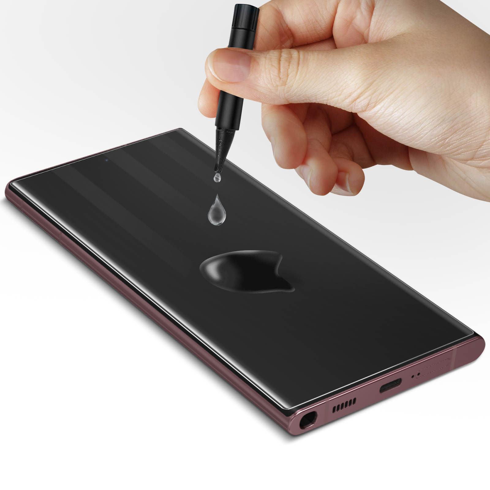 Mano che tiene un telefono nero con gocce di liquido. Lo schermo è nero, sfondo bianco.