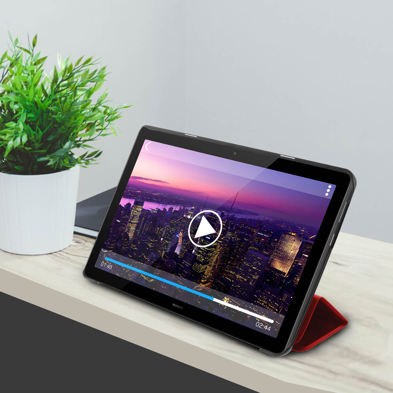 Un tablet su un supporto sta riproducendo un video. Una pianta e una tastiera sono sullo sfondo.