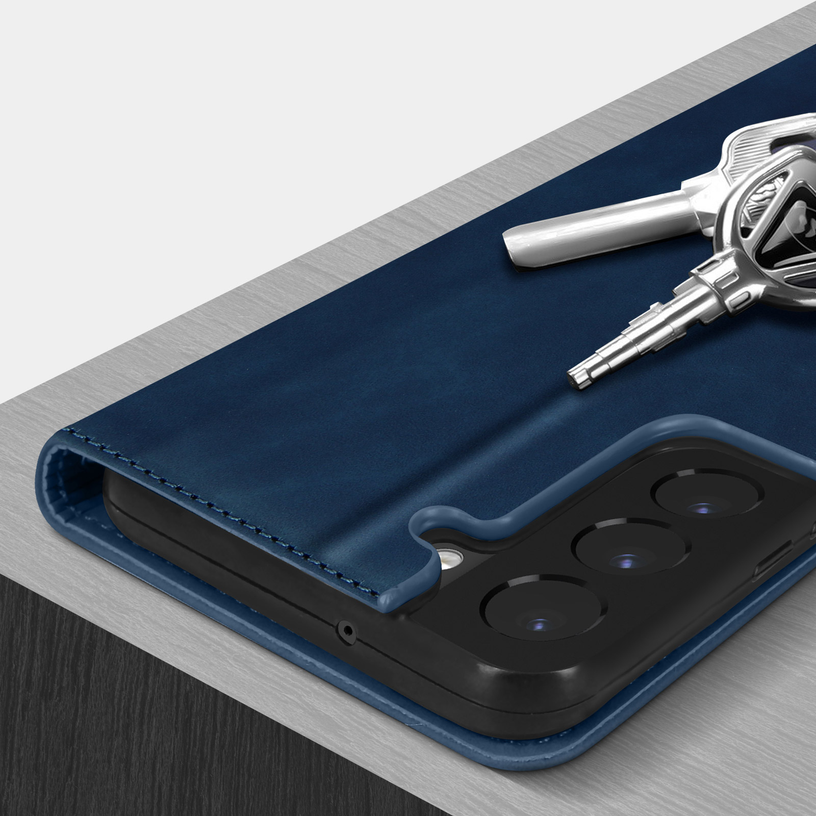 Un telefono all'interno di una custodia blu, con chiavi appoggiate sulla custodia.