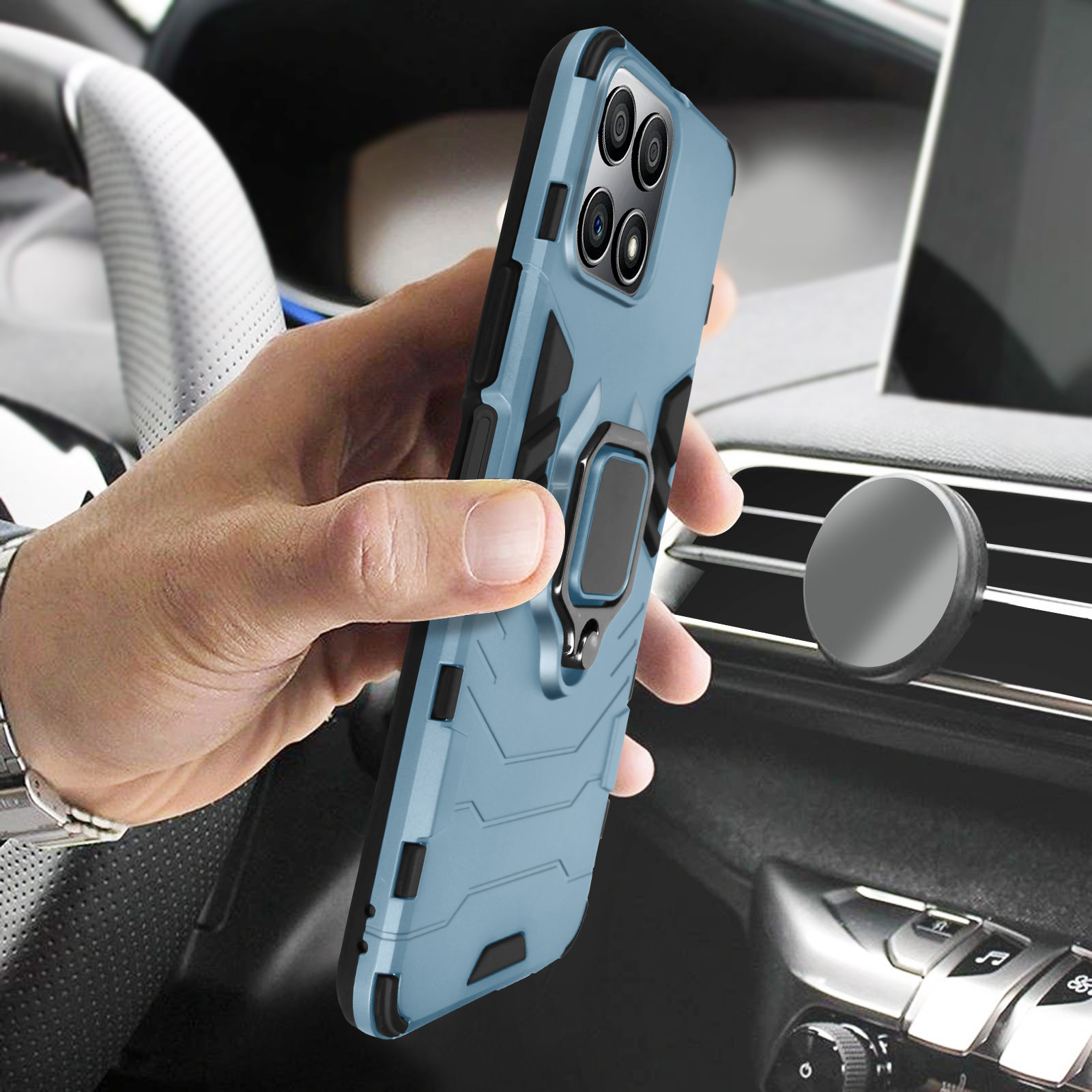 Una mano che tiene una custodia blu per telefono con un supporto ad anello, in un'auto. La custodia è sul cruscotto.
