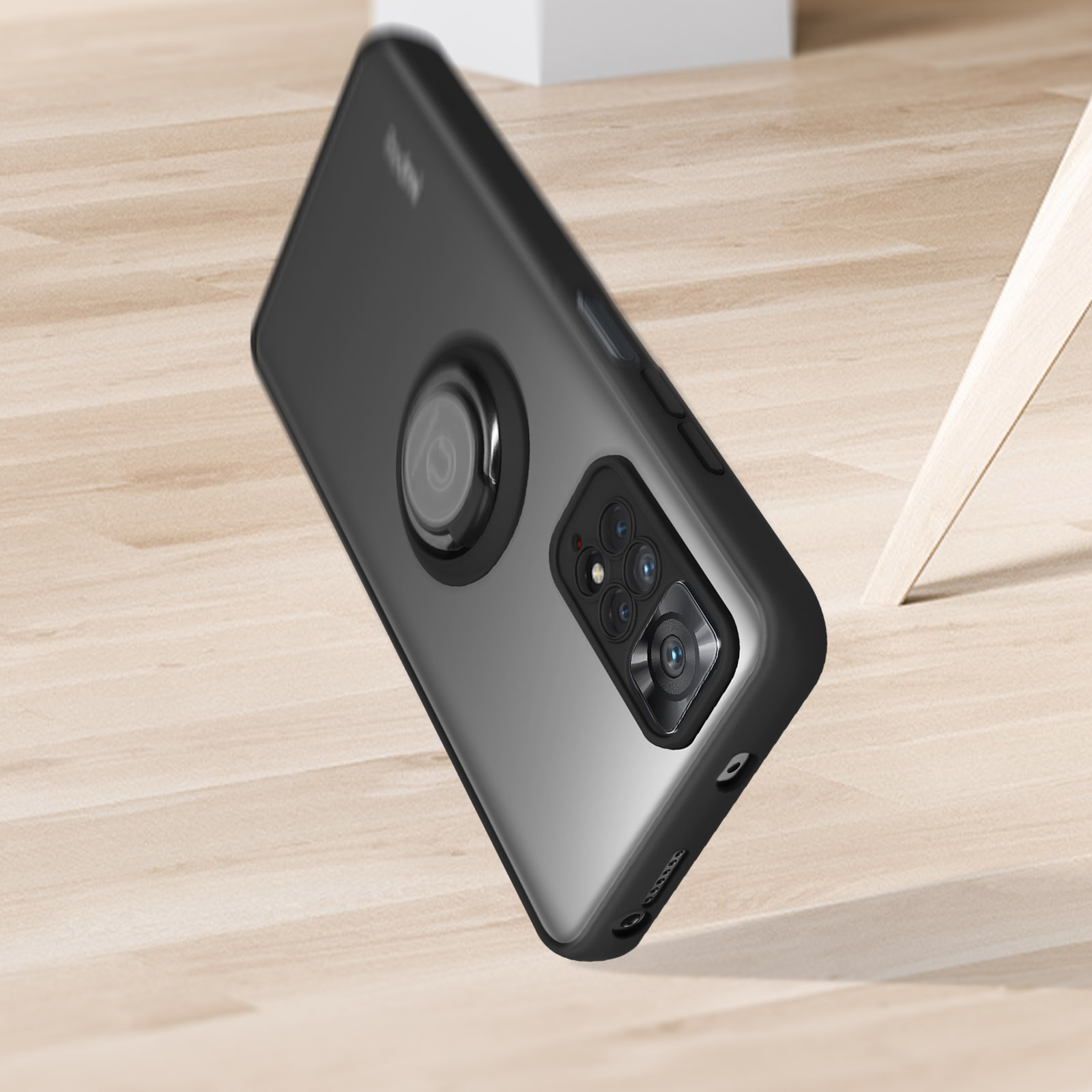 Een zwarte telefoonhoes met een ringhouder, liggend op een houten oppervlak.