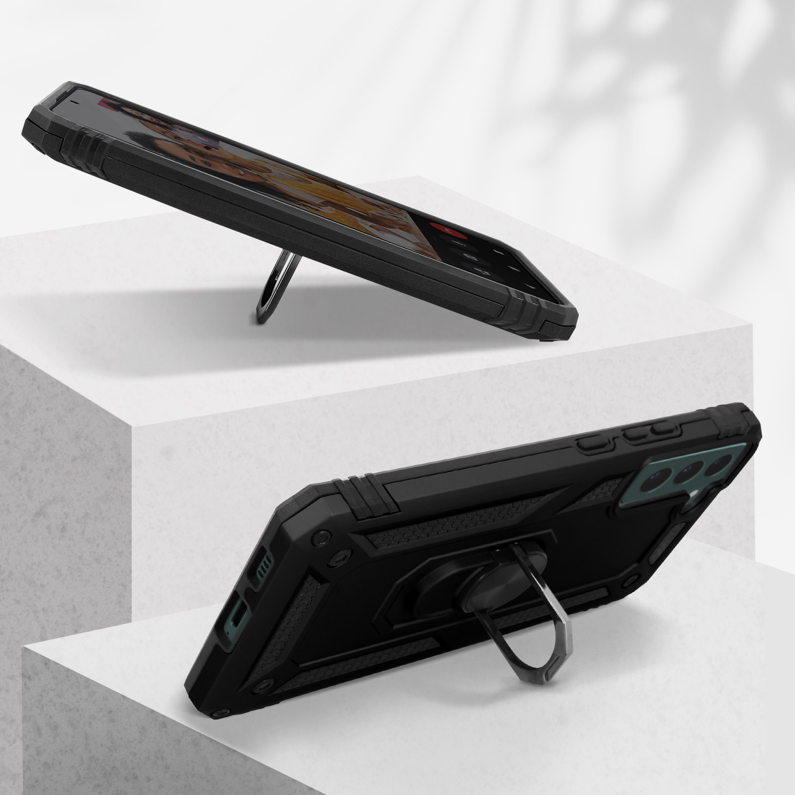 Twee zwarte telefoonhoesjes, één omhoog en één omlaag gekanteld, elk met een ringhouder.