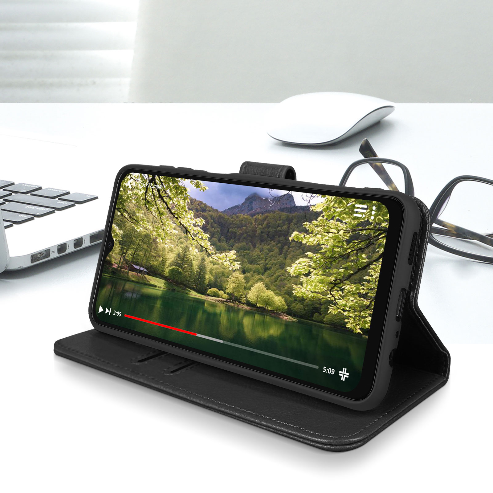 Zwarte telefoon in een hoes, met een video van een meer met bomen. De telefoon staat op een bureau.