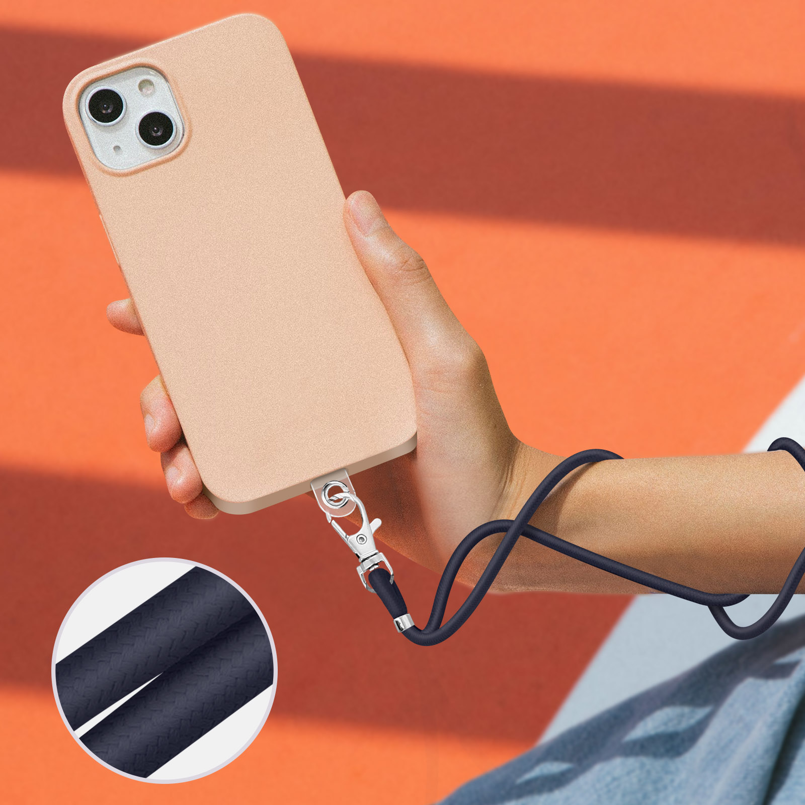 Una mano tiene un telefono beige chiaro con un cinturino da polso scuro attorno al braccio.