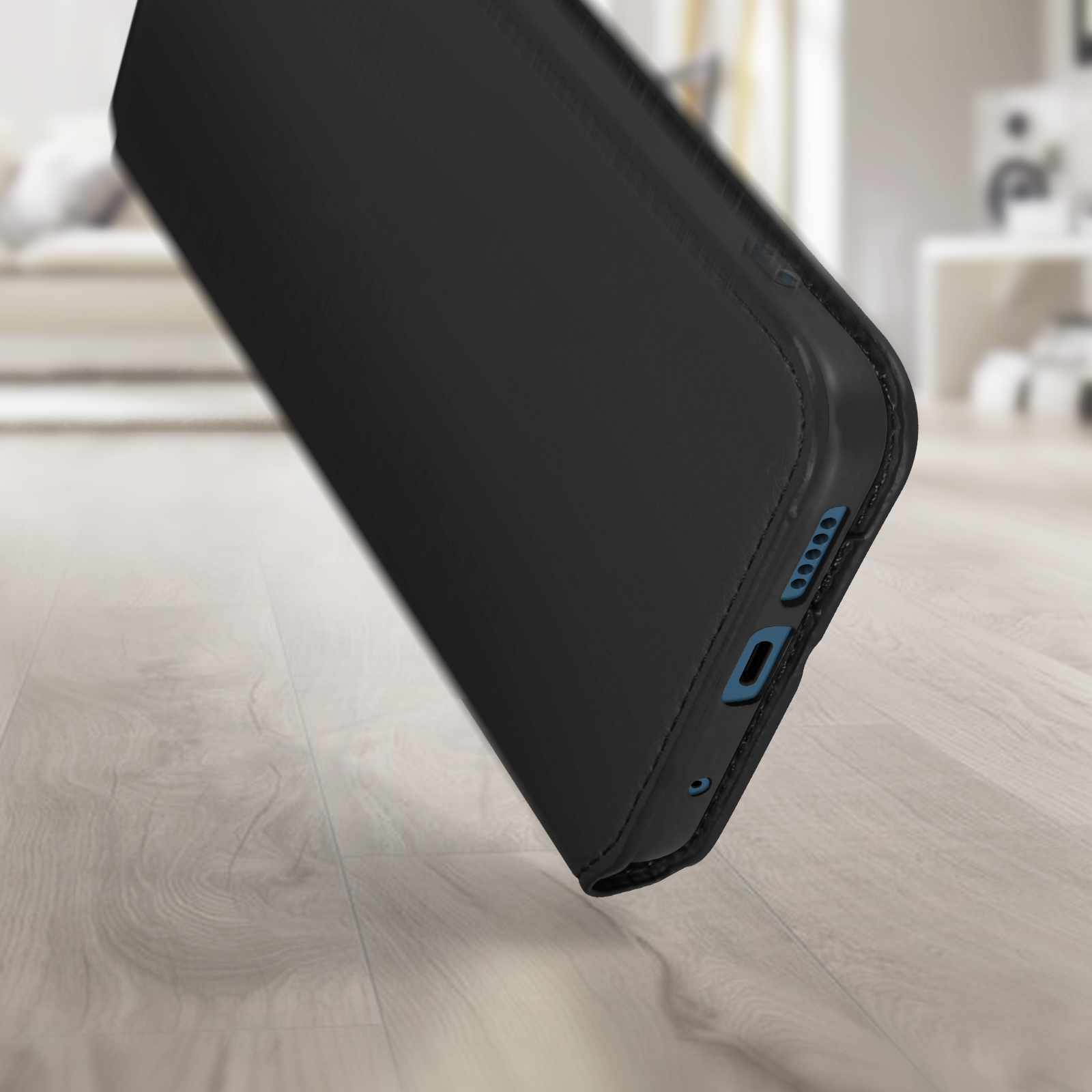 Un étui de téléphone noir est fermé et posé sur une surface en bois. L'étui affiche quelques boutons.