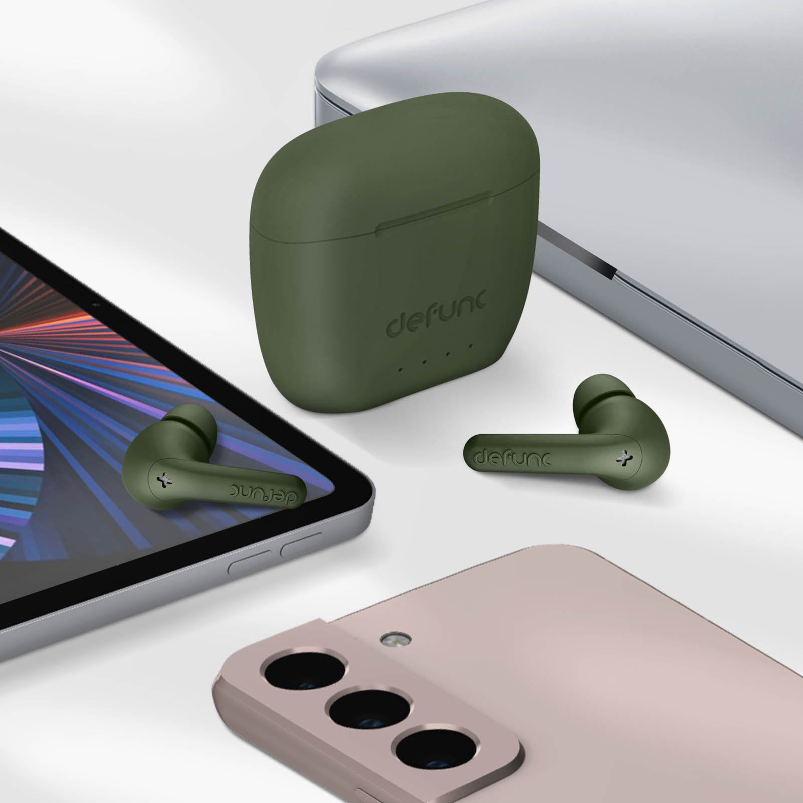 Auricolari, custodia di ricarica, tablet e un telefono. Gli auricolari e la custodia sono verdi. Il telefono è rosa.