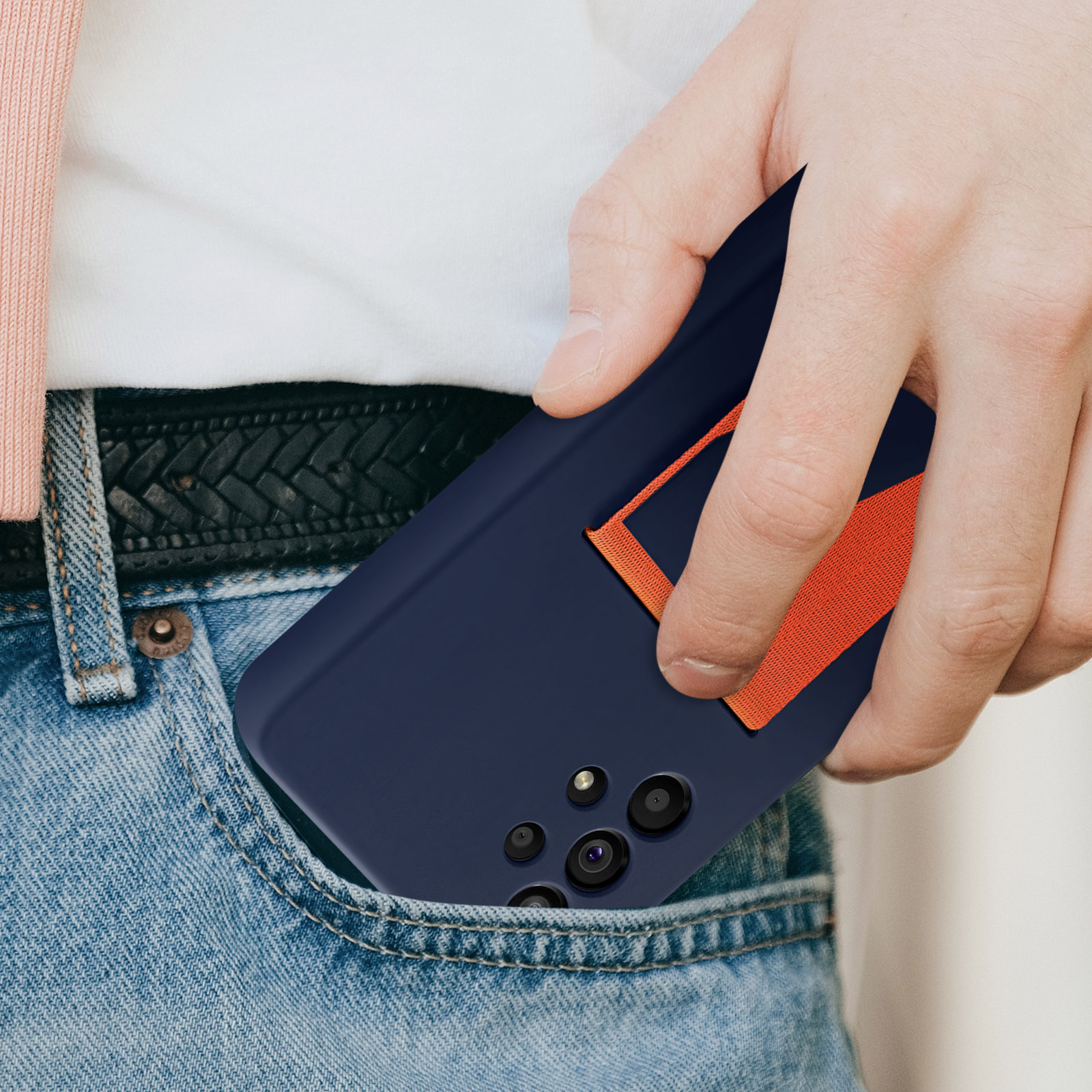 Eine Hand hält ein blaues Telefon mit einem orangefarbenen Riemen in einer Tasche.