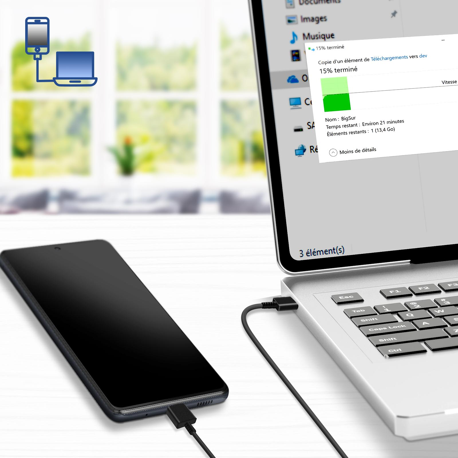Ein Telefon, das mit einem Laptop verbunden ist und eine Dateiübertragung zeigt. Das Telefon ist schwarz und der Laptop ist geöffnet.