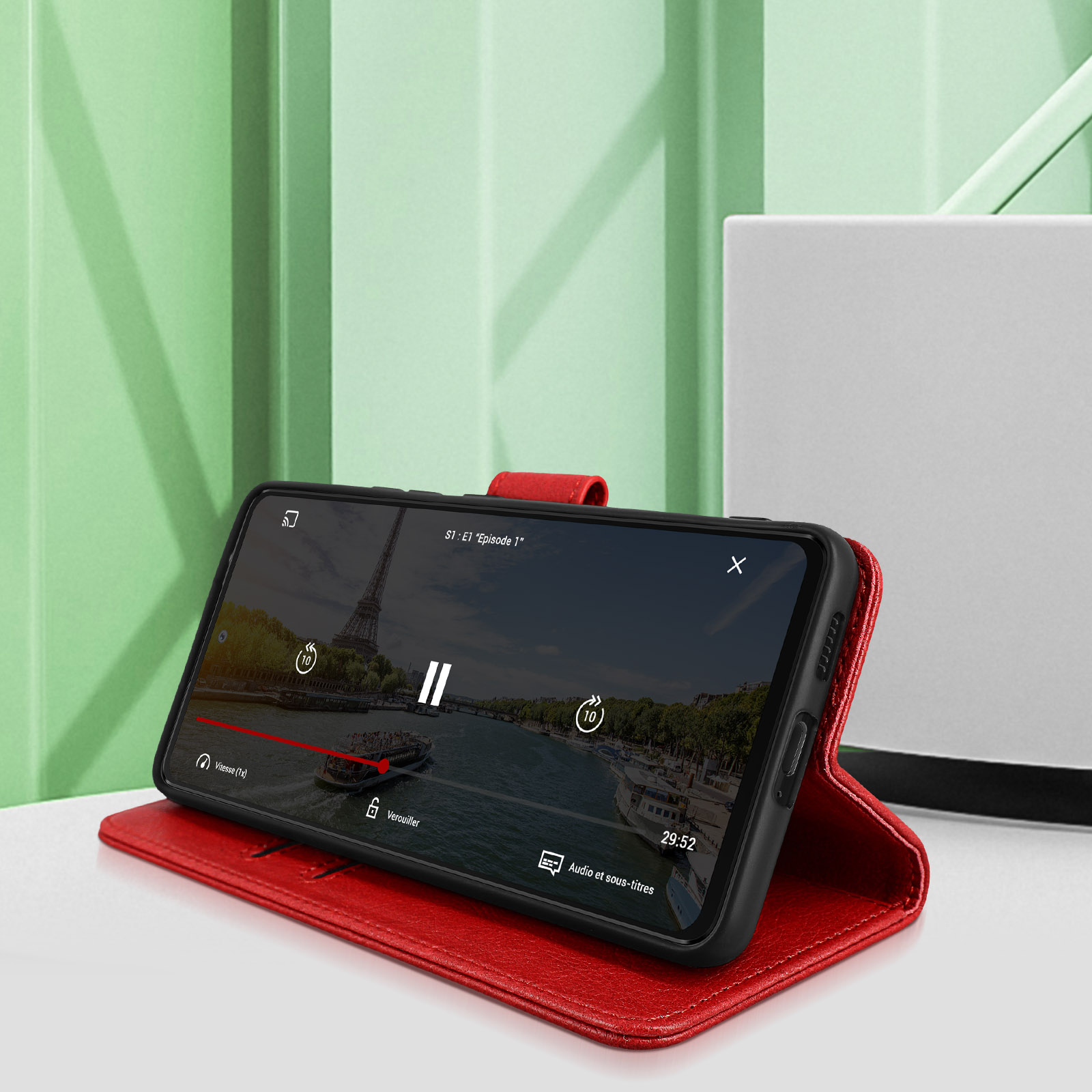 Un étui de téléphone rouge contenant un téléphone, diffusant une vidéo avec la tour Eiffel.