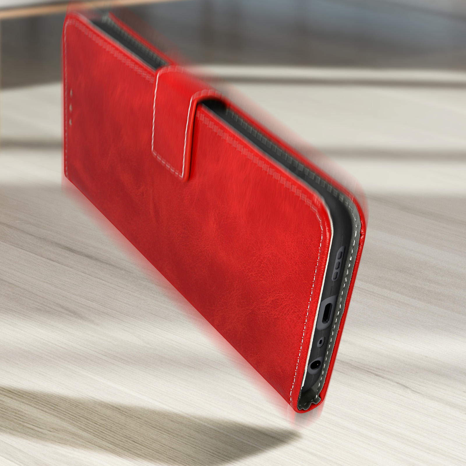 Custodia rossa con texture in pelle, aperta su superficie in legno.