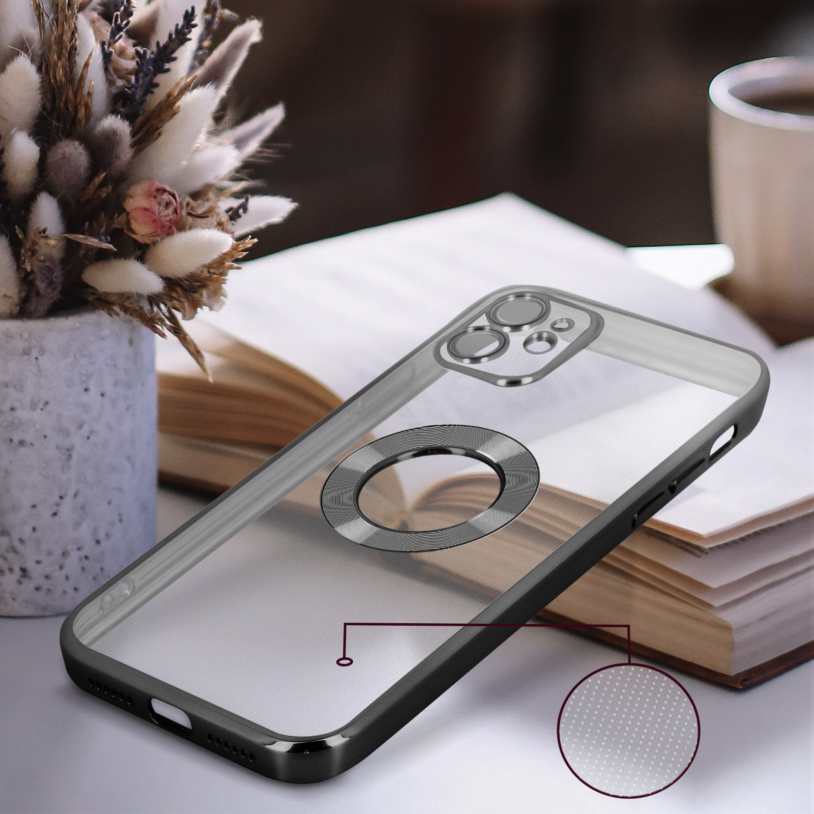 Custodia trasparente con anello argentato, su un tavolo con vaso di fiori e libro. La custodia ha un anello.