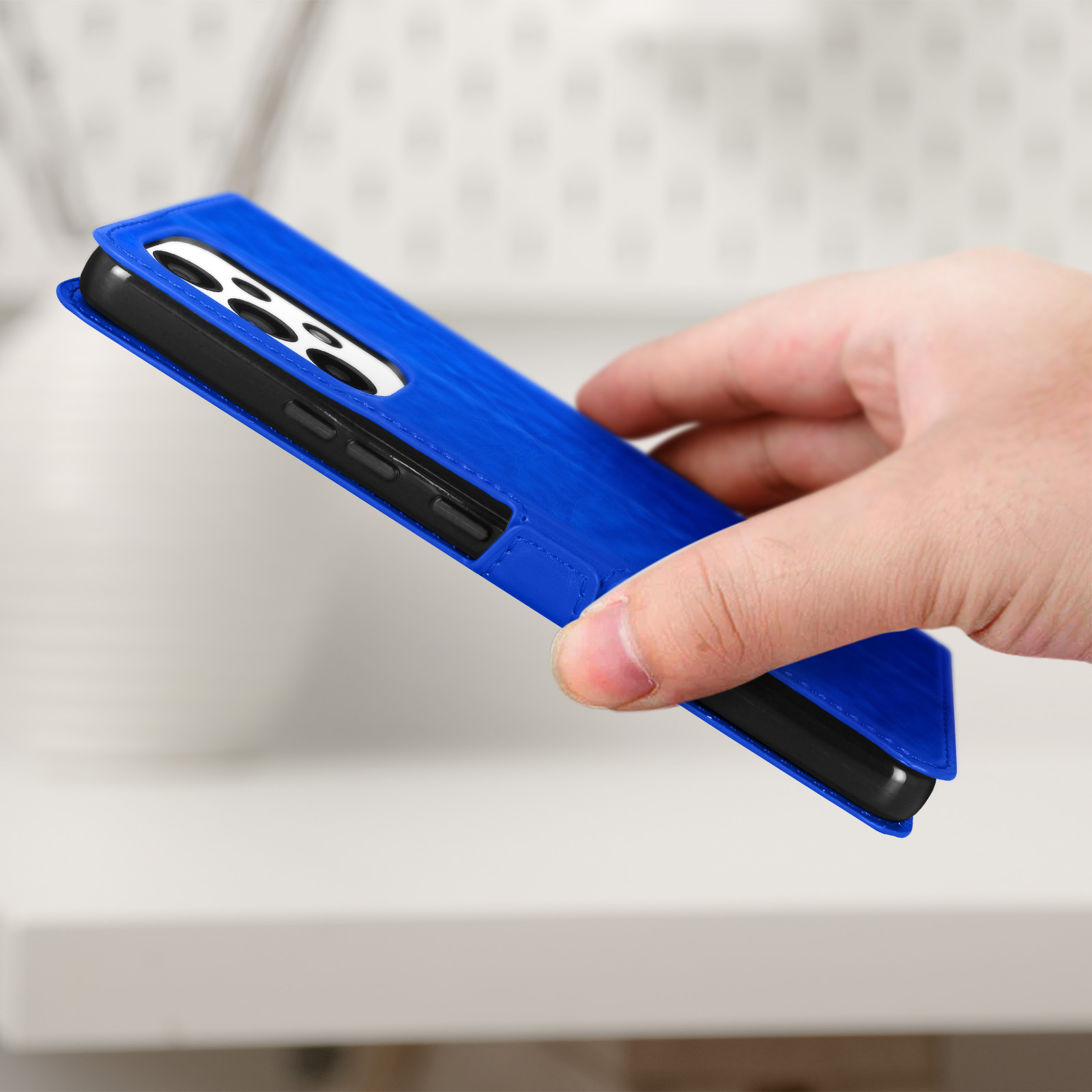 Un étui de téléphone bleu maintenu ouvert, montrant le téléphone à l'intérieur.