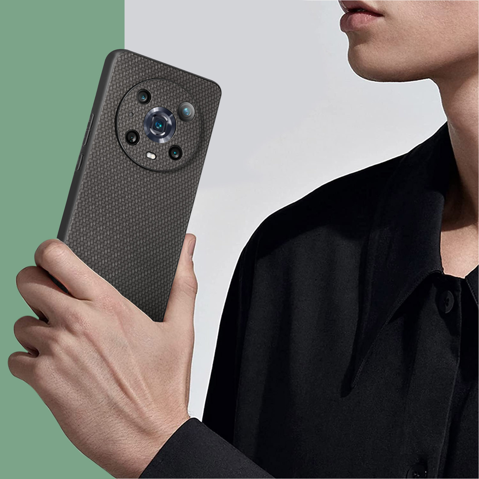 Una persona tiene in mano un telefono grigio scuro con un sistema di fotocamere circolare. Indossa una camicia nera, mostrando il design del telefono.