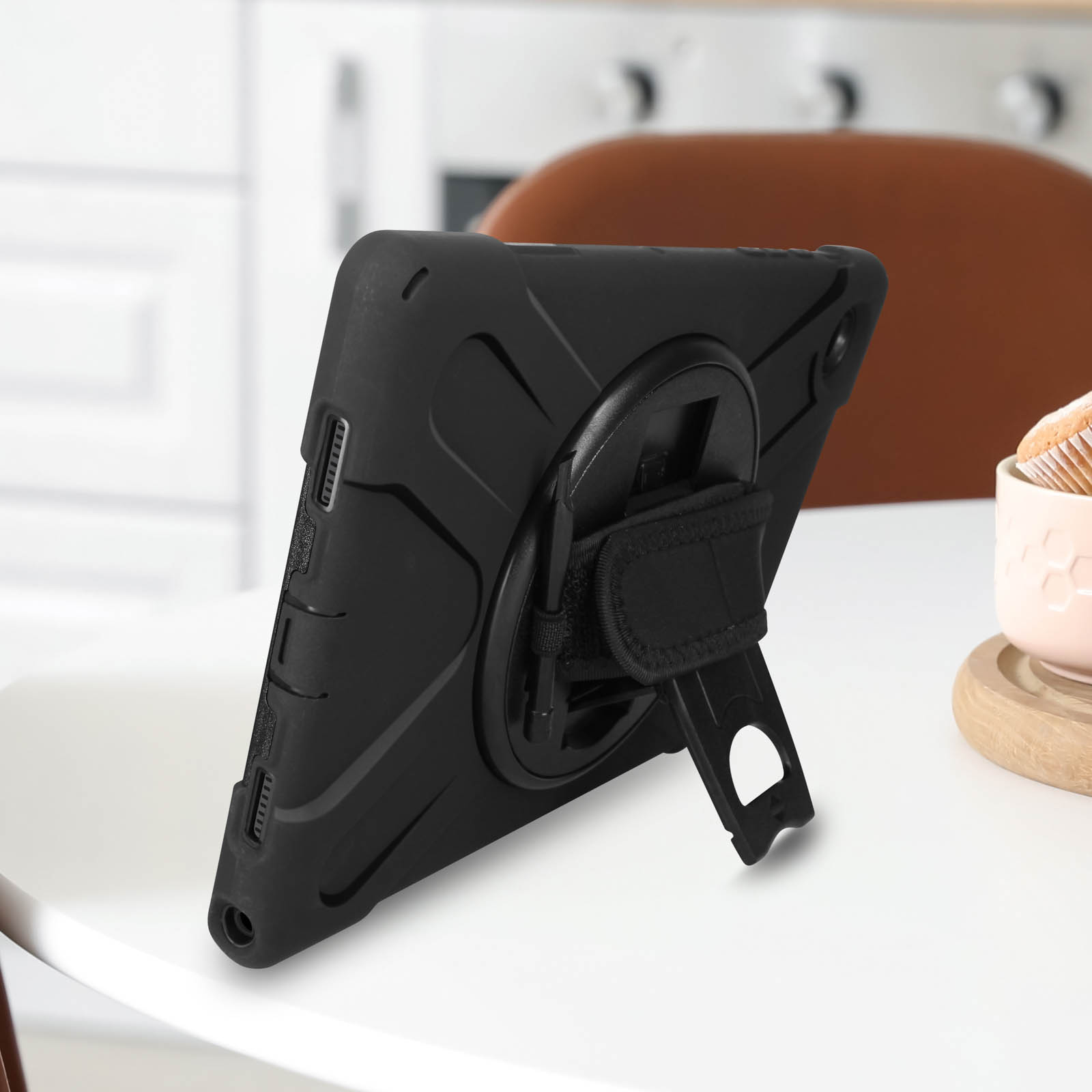 Schwarze Tablet-Hülle auf einem weißen Tisch, mit Ständer und Handschlaufe.