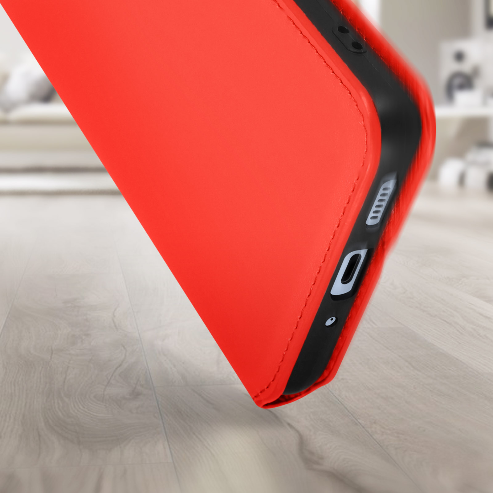 Rode telefoonhoes open. De hoes ligt op een houten vloer.