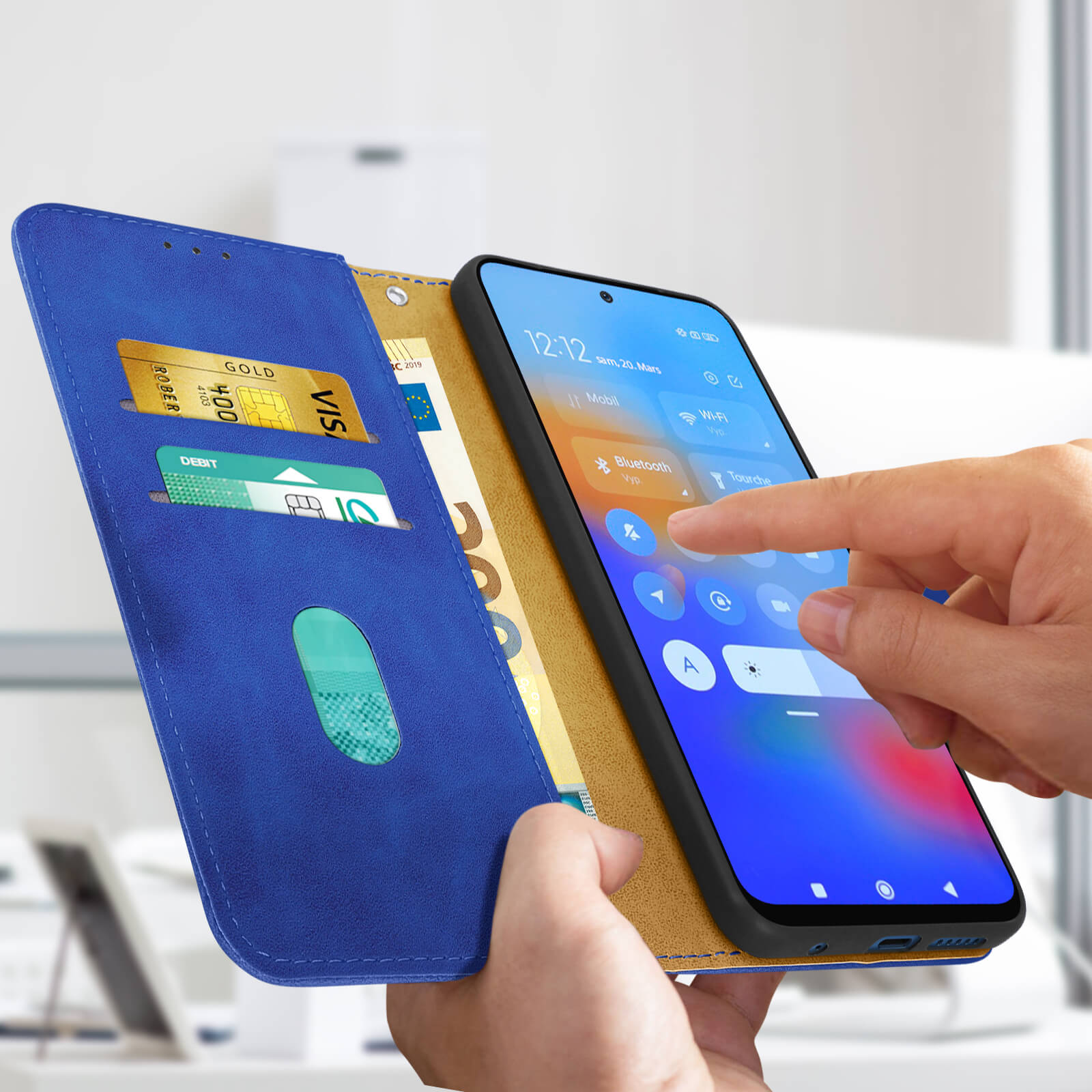 Un étui de téléphone bleu avec fente pour cartes, contenant un téléphone et des cartes, touché par un doigt.