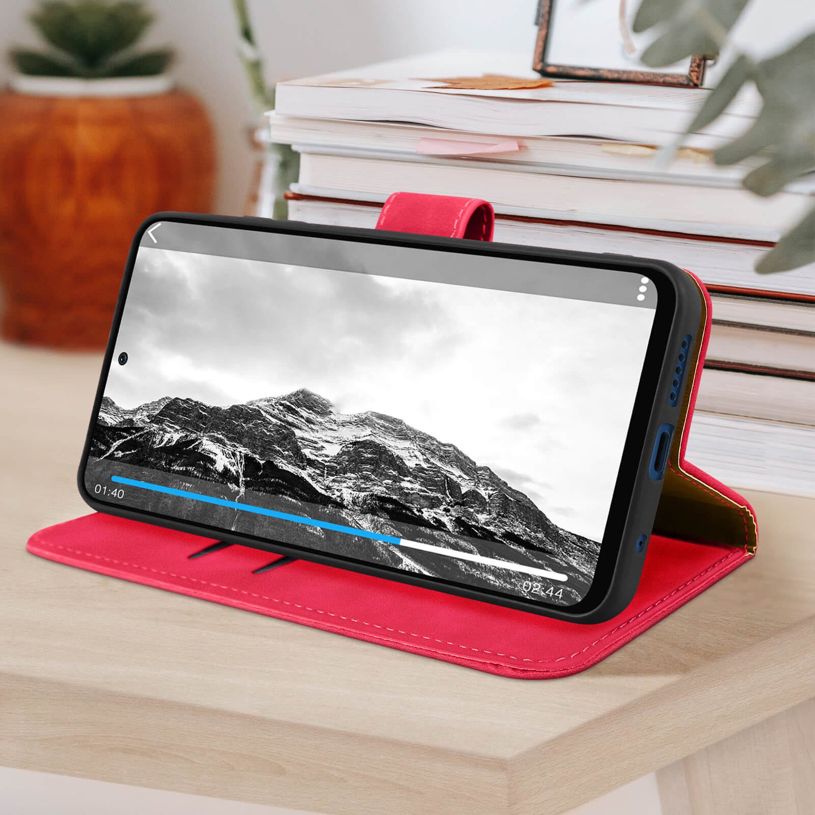 Telefoon in een roze case met een video. Case staat op een oppervlak.