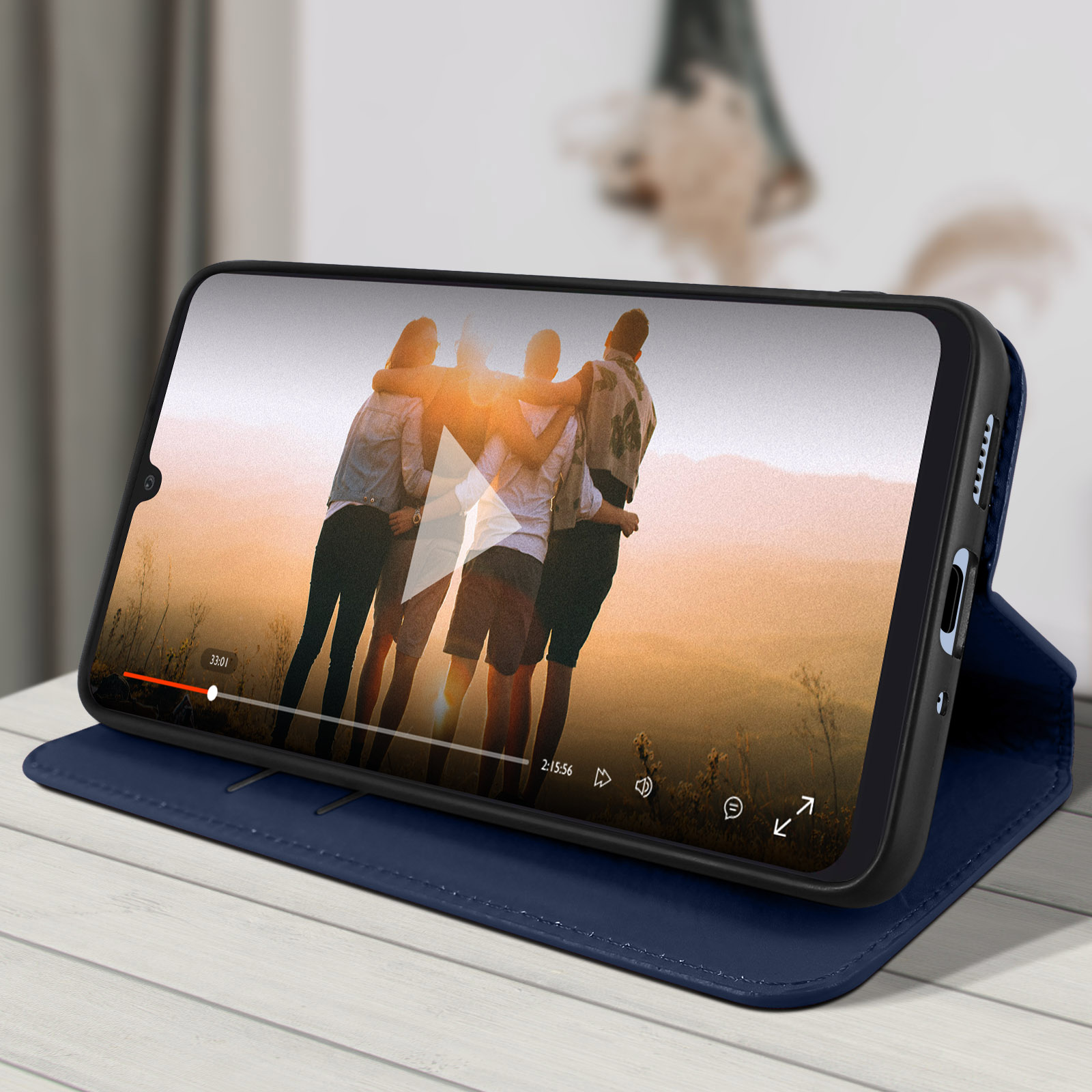 Telefoon in blauwe case met video. Houten tafel. Vage achtergrond.