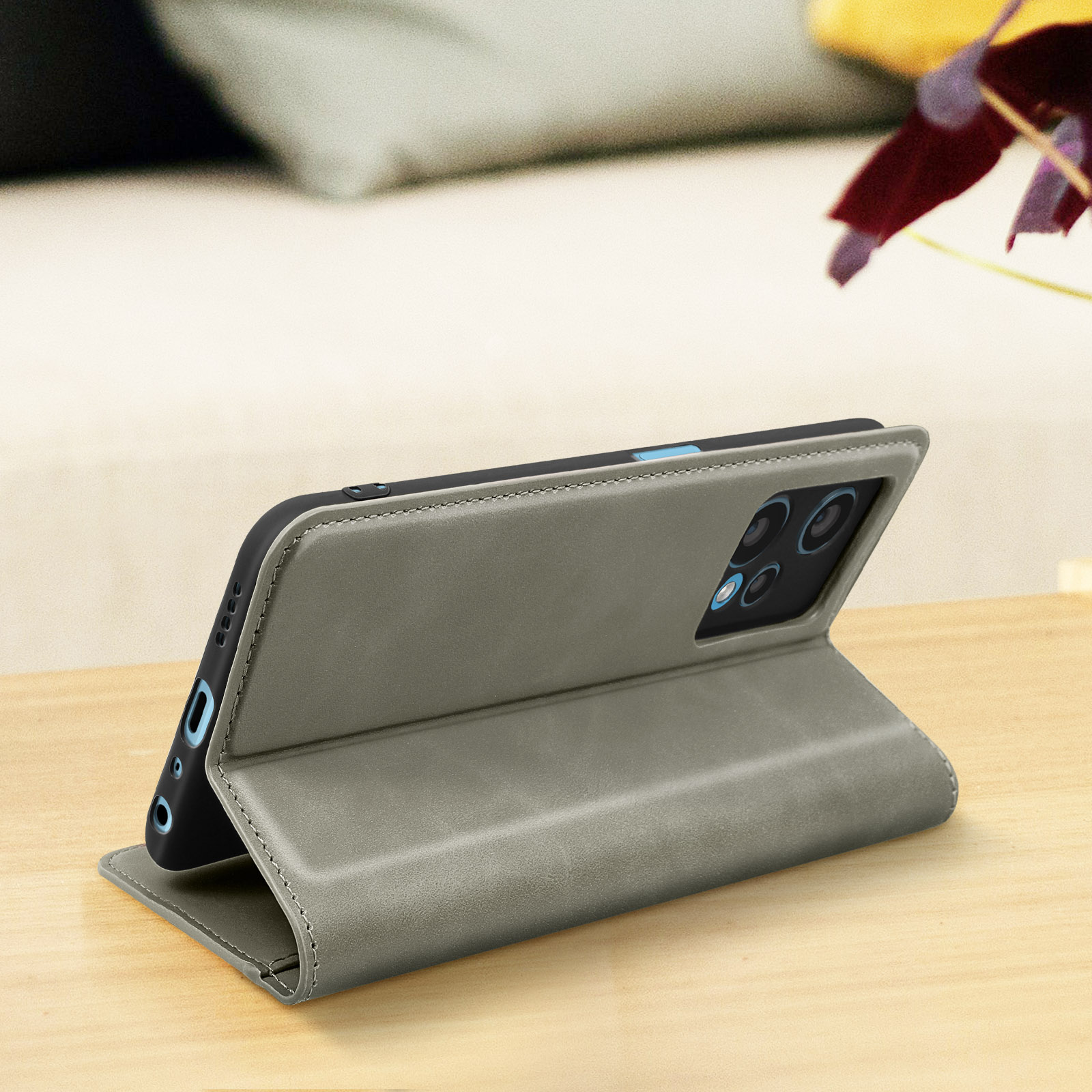 Custodia grigia per telefono su un tavolo di legno, con telefono all'interno. La custodia è aperta.
