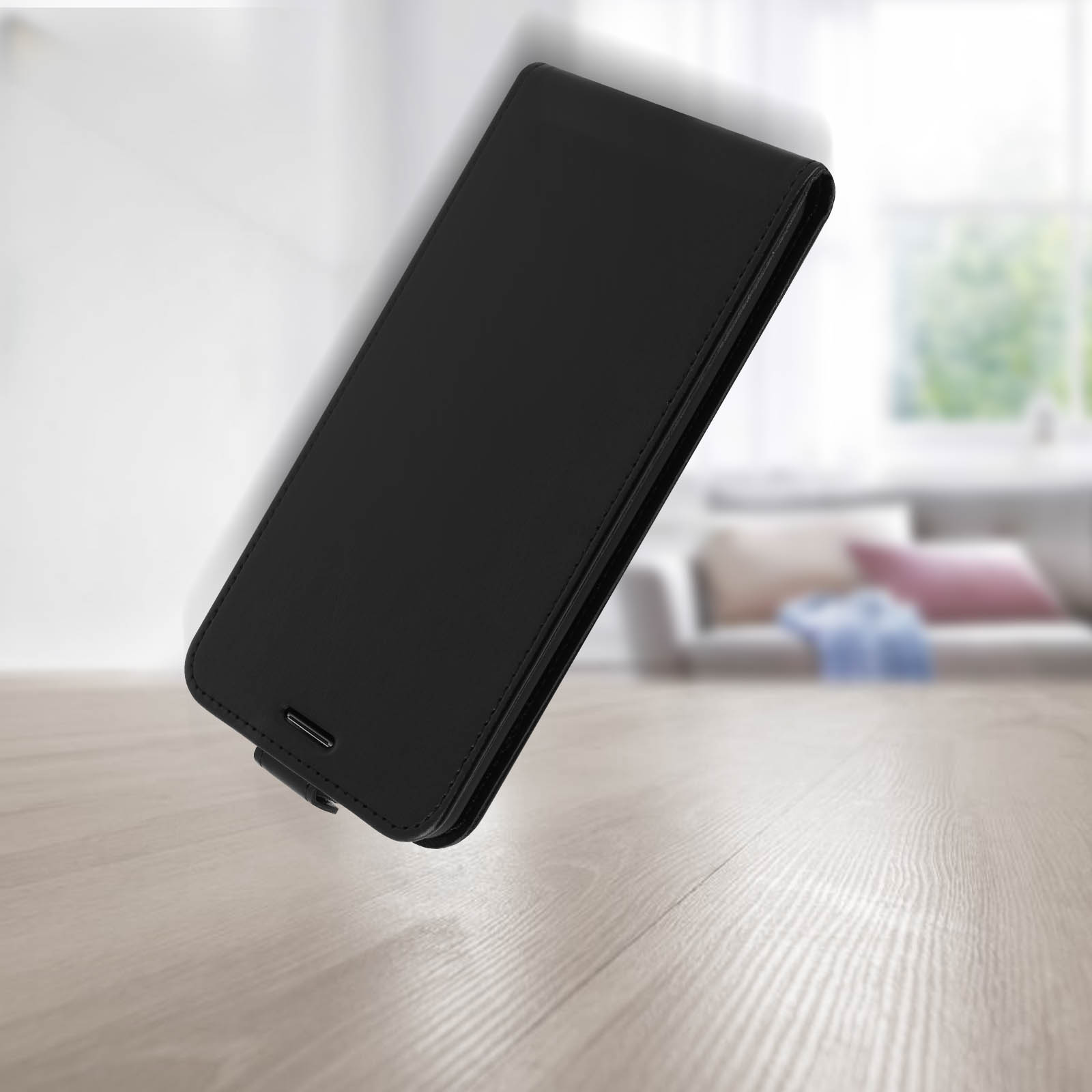 Custodia per telefono nera, chiusa. Vista angolata su una superficie in legno. Design minimalista, texture simile alla pelle.