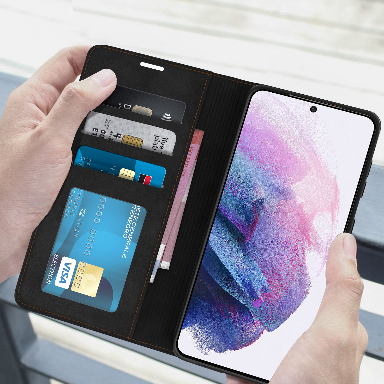Custodia nera per telefono con fessure per carte, aperta per rivelare carte e denaro. Mani.