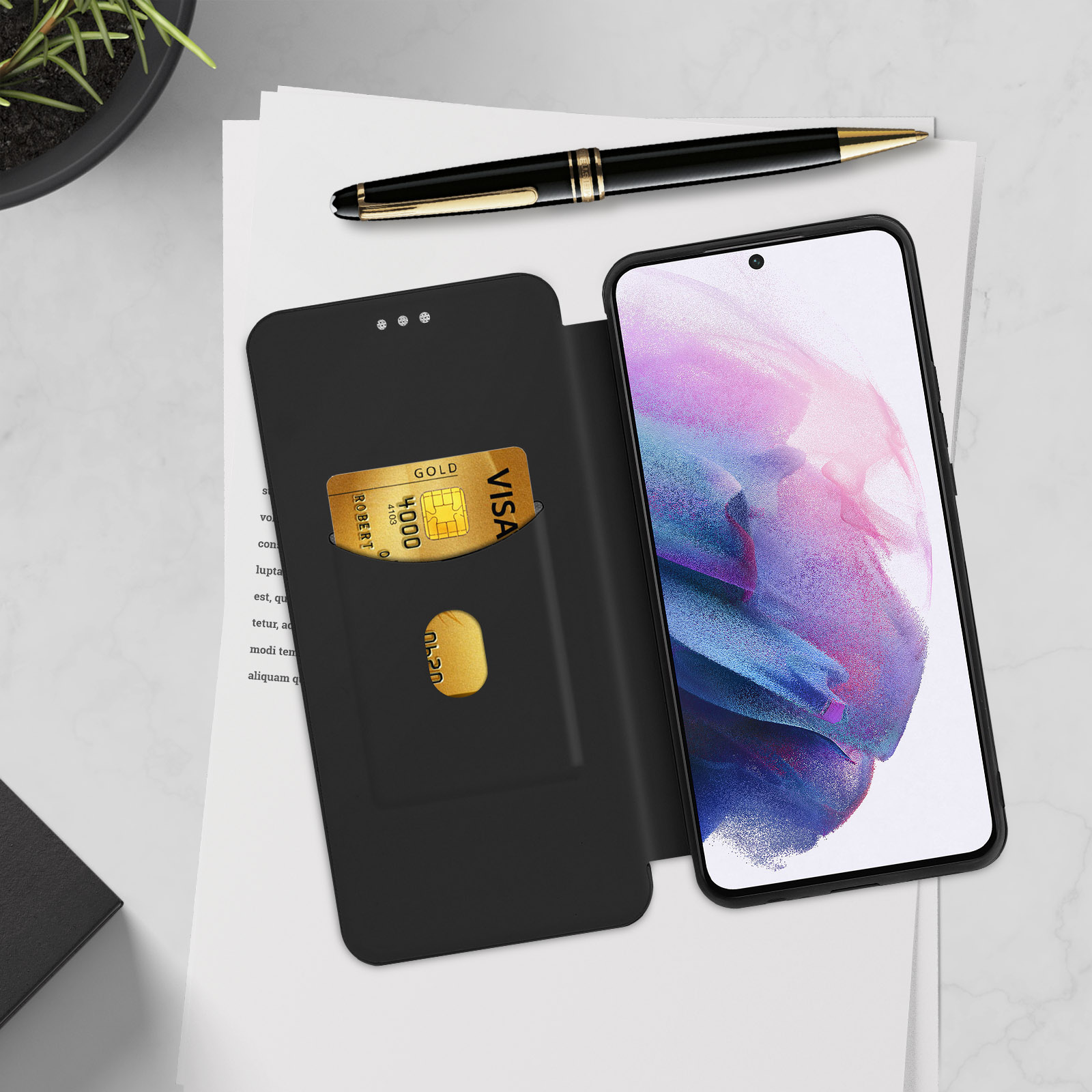 Custodia nera per telefono con carta VISA oro. Una penna e un telefono su una superficie bianca.