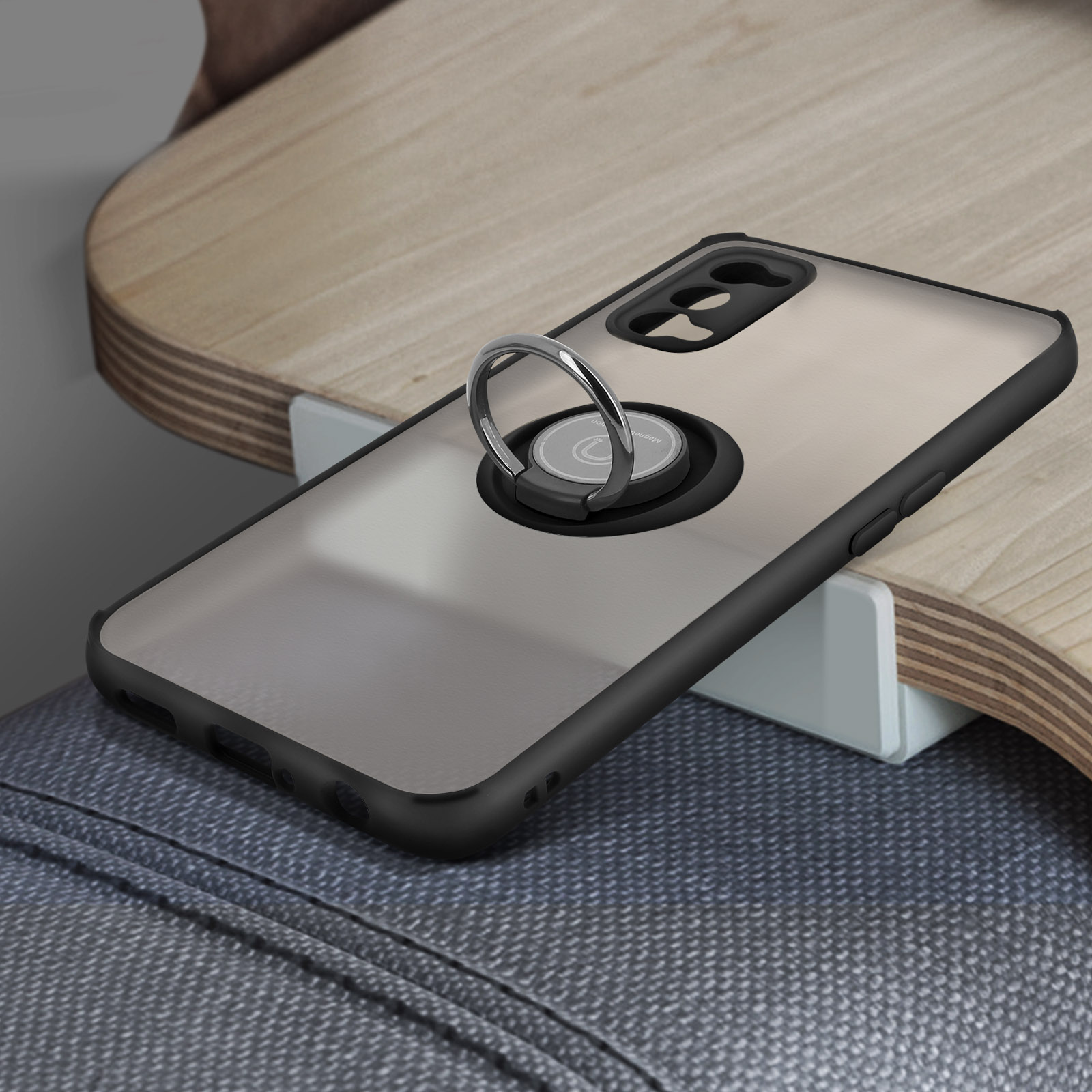 Una custodia per telefono con un supporto ad anello su una superficie in legno. La custodia è nera e l'anello è argento.