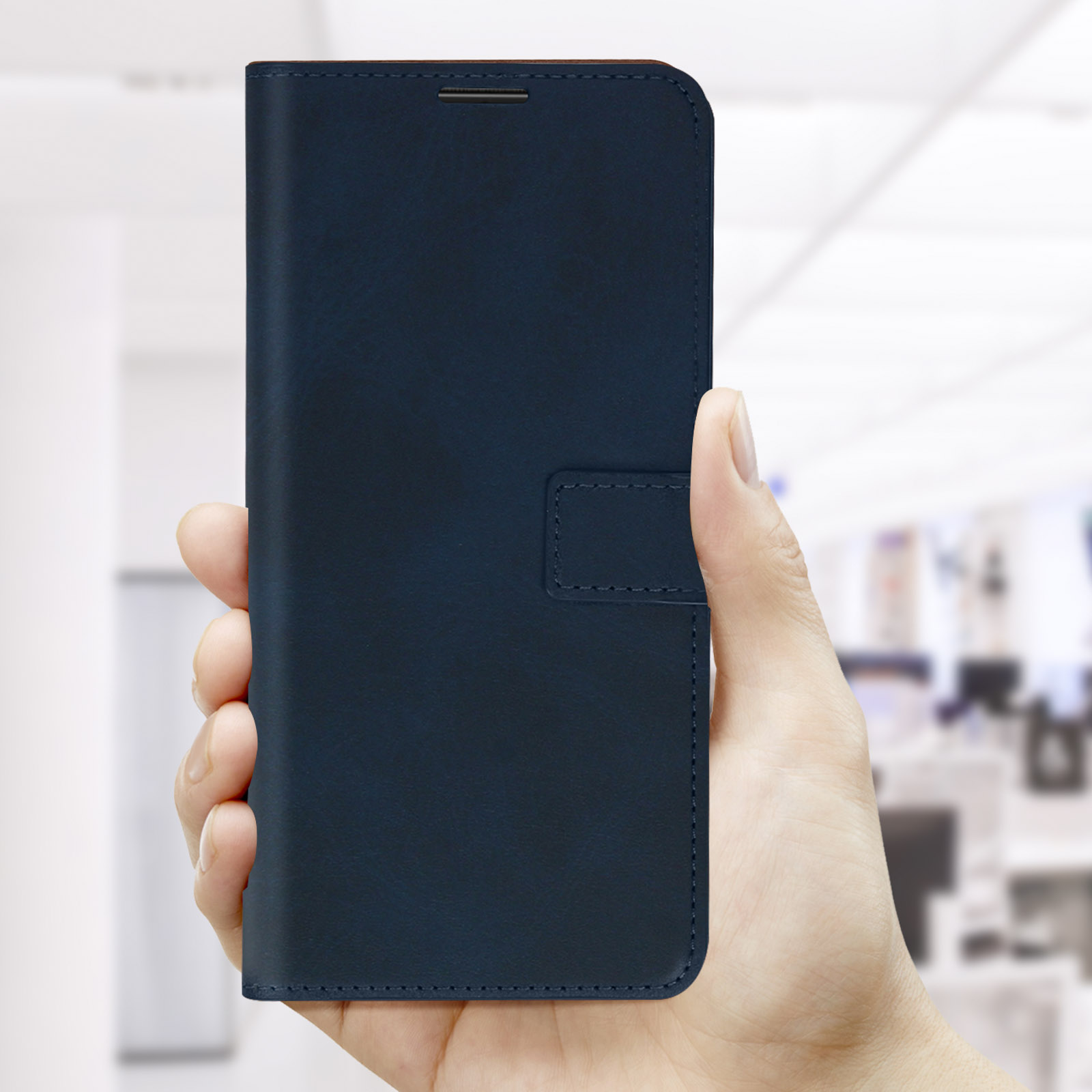 Hand die een blauwe telefoonhoes vasthoudt. Achtergrond is een wazig kantoor.