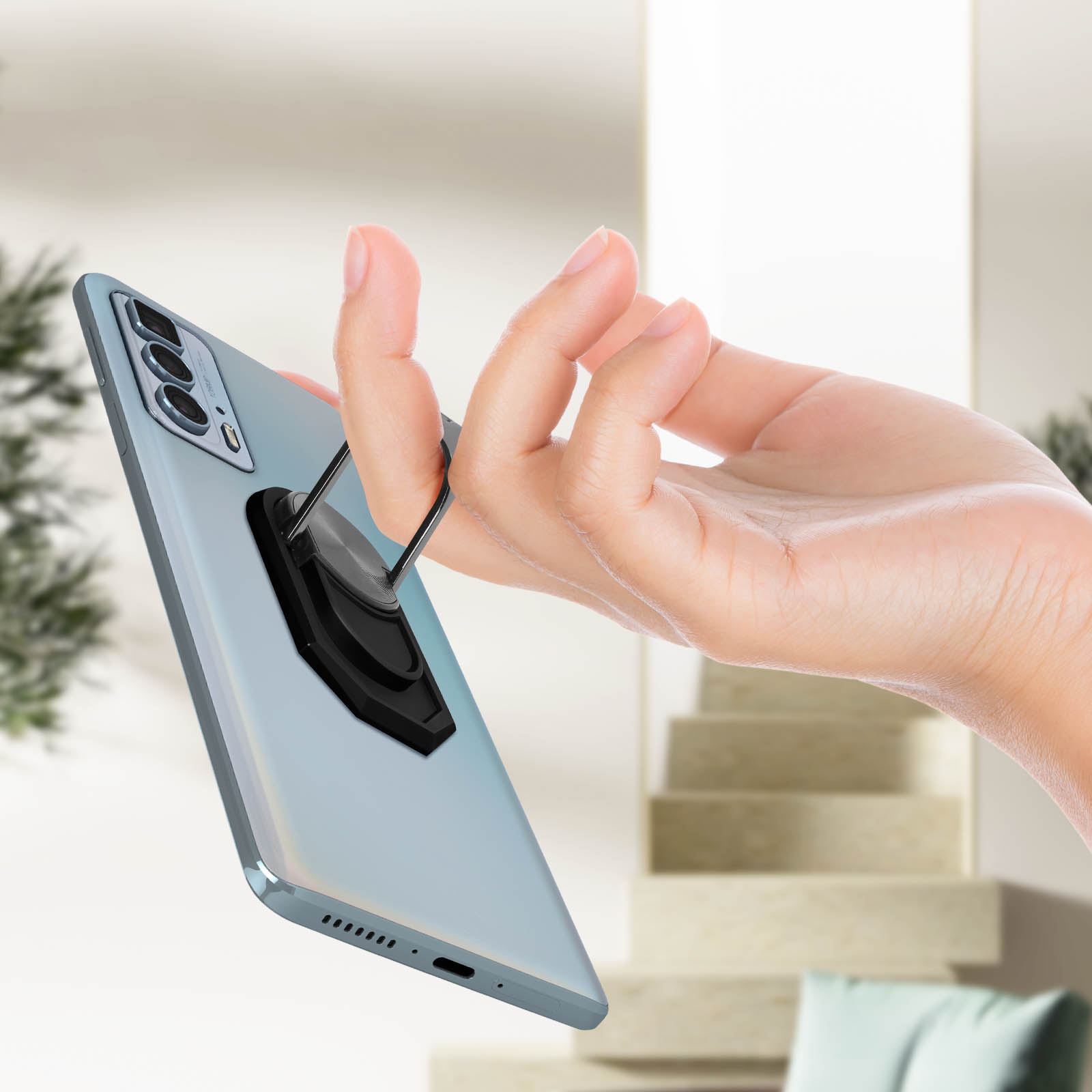 Una mano tiene un telefono con un anello. Il telefono è azzurro.