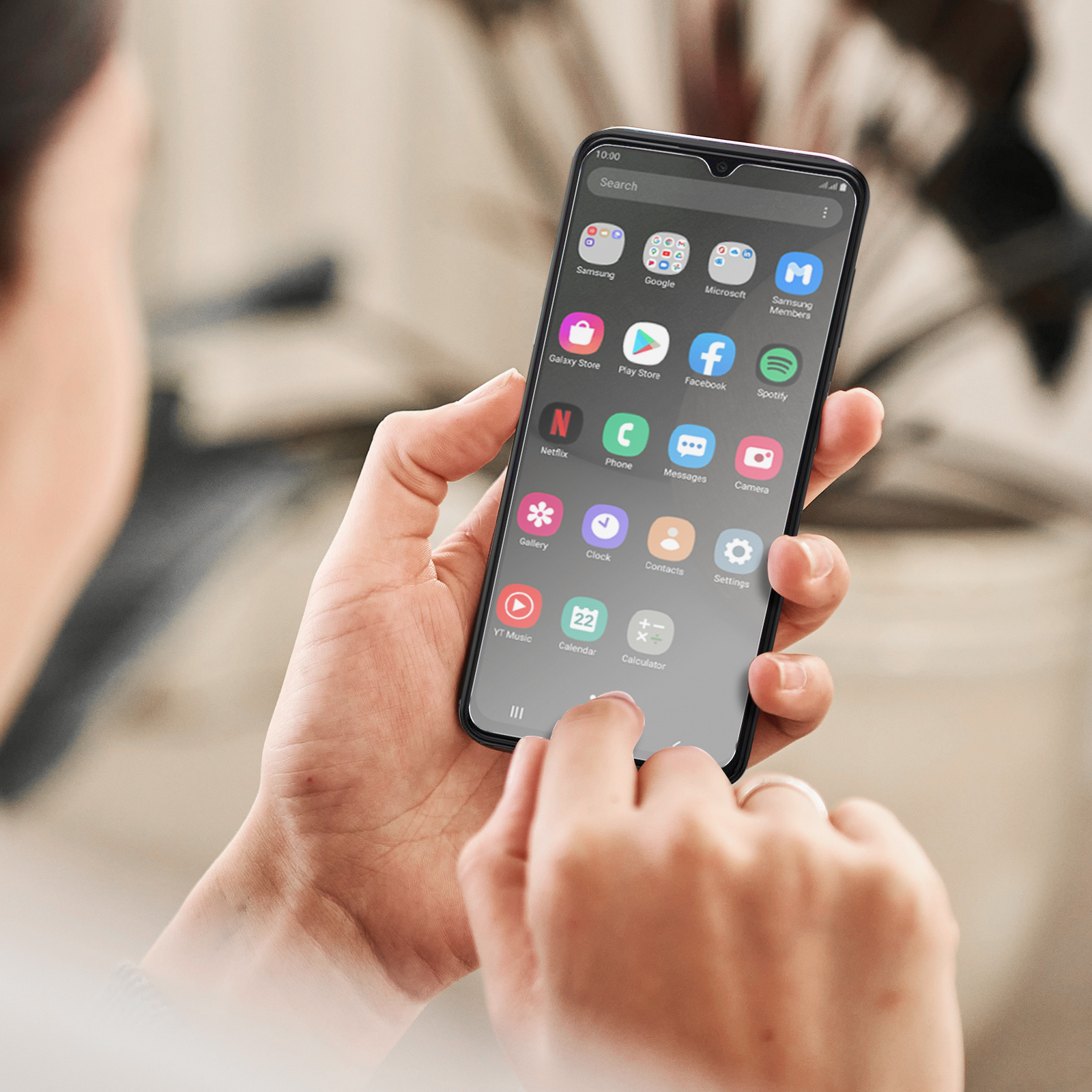 Mani che tengono un telefono che mostra icone di app sullo schermo. Il telefono ha una cornice nera.