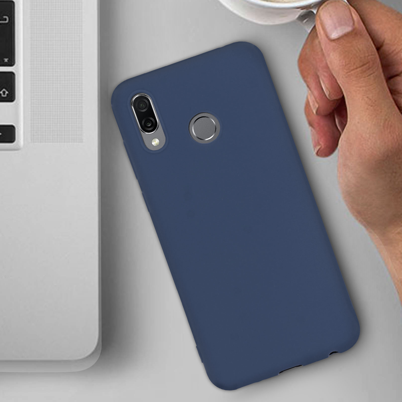 Una custodia blu con un telefono all'interno è posizionata su un tavolo accanto a un laptop e una tazza di caffè.