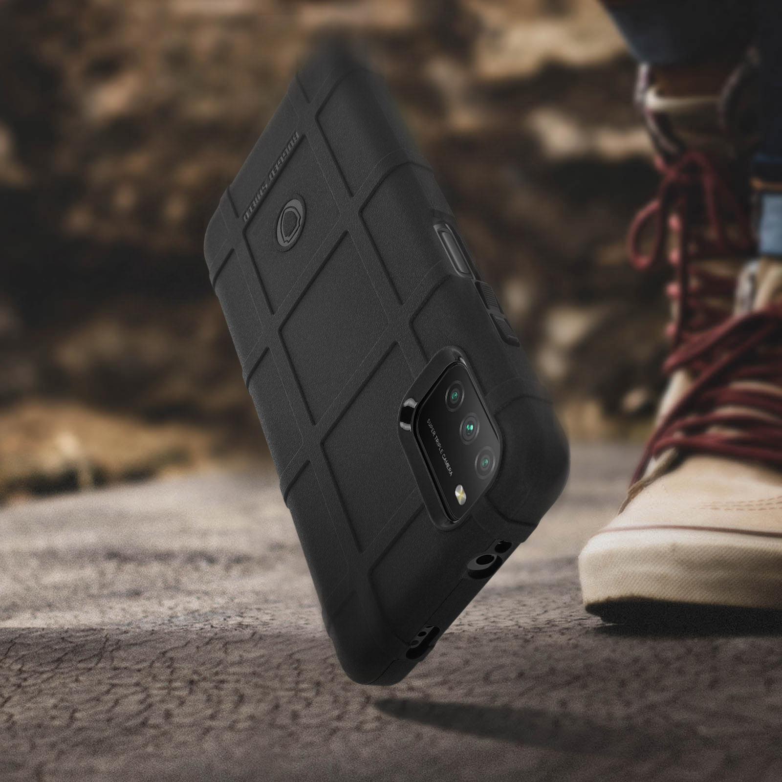 Custodia nera per telefono con motivo a griglia, su superficie ruvida, vicino a una scarpa.