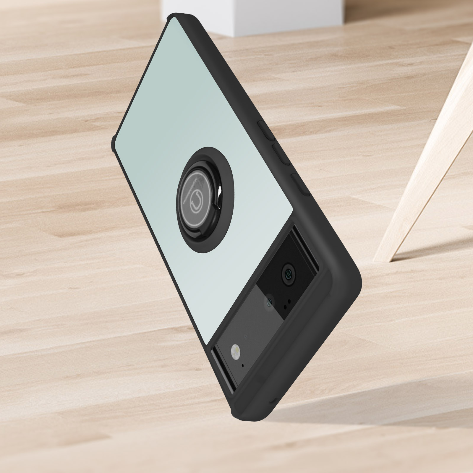 Een zwarte telefoonhoes met een spiegelende achterkant. Het ligt op een houten vloer.