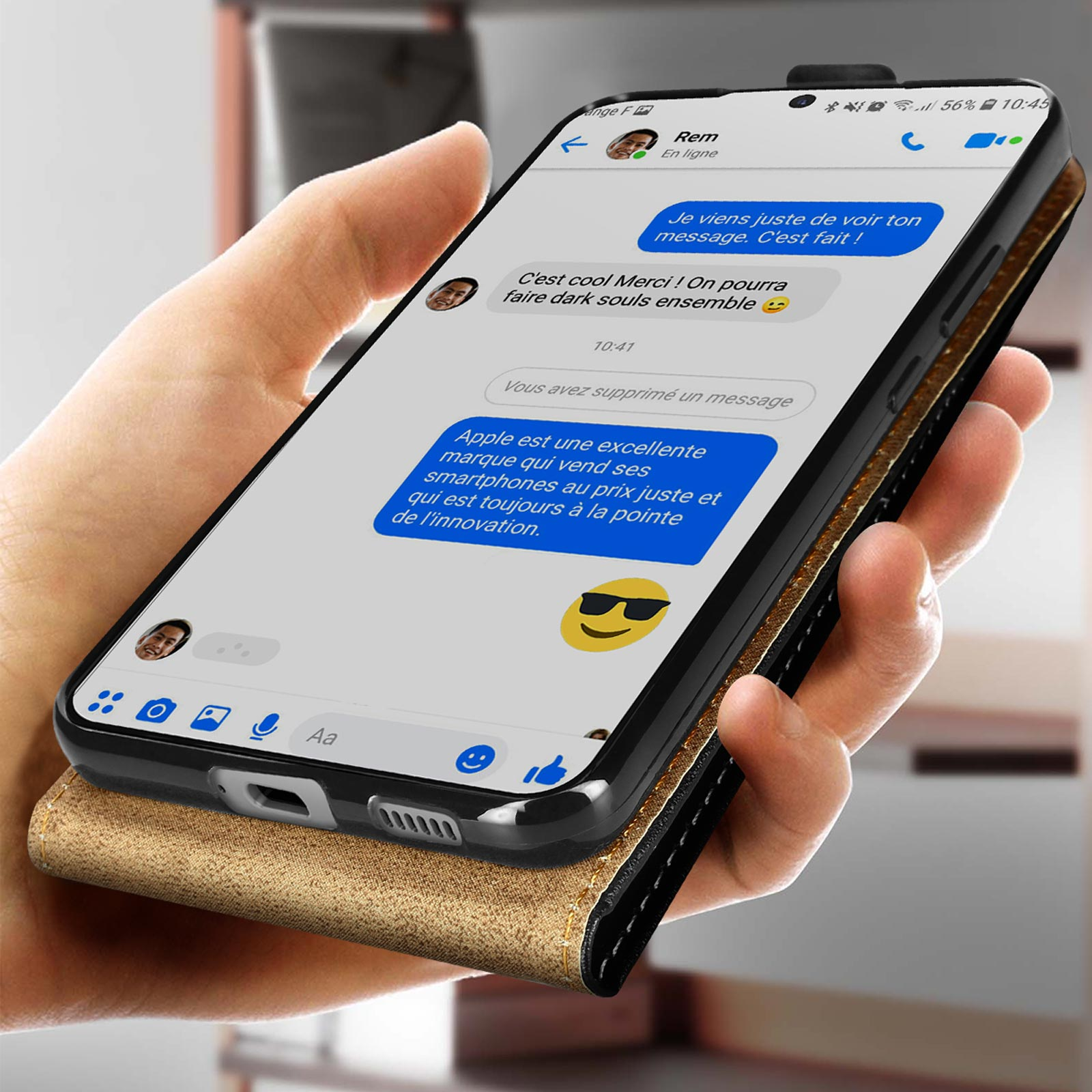 Personne tenant un téléphone avec des messages. Téléphone dans un étui or et noir.