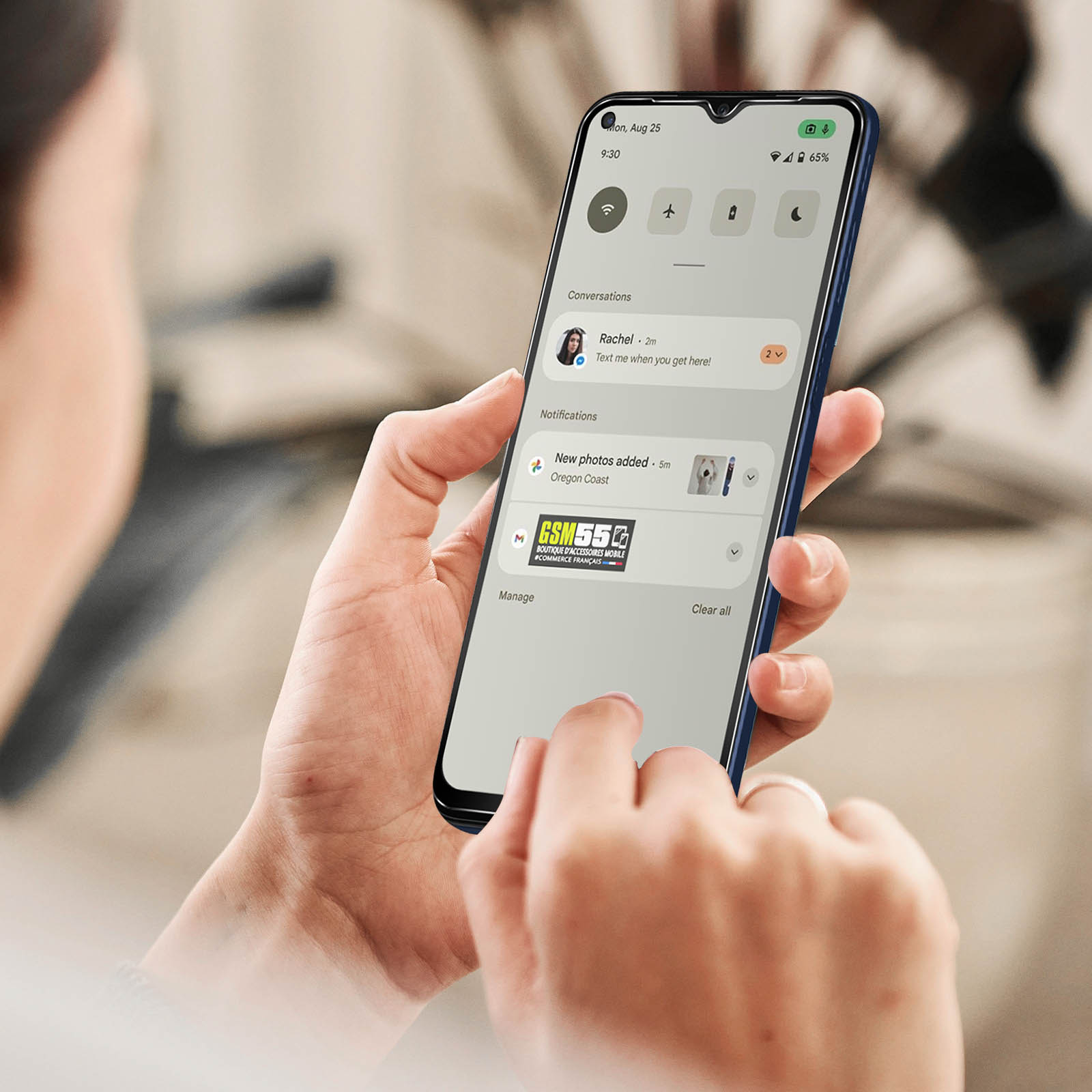 Una persona che tiene un telefono che mostra le notifiche. Lo schermo mostra testi, l'ora e varie icone.