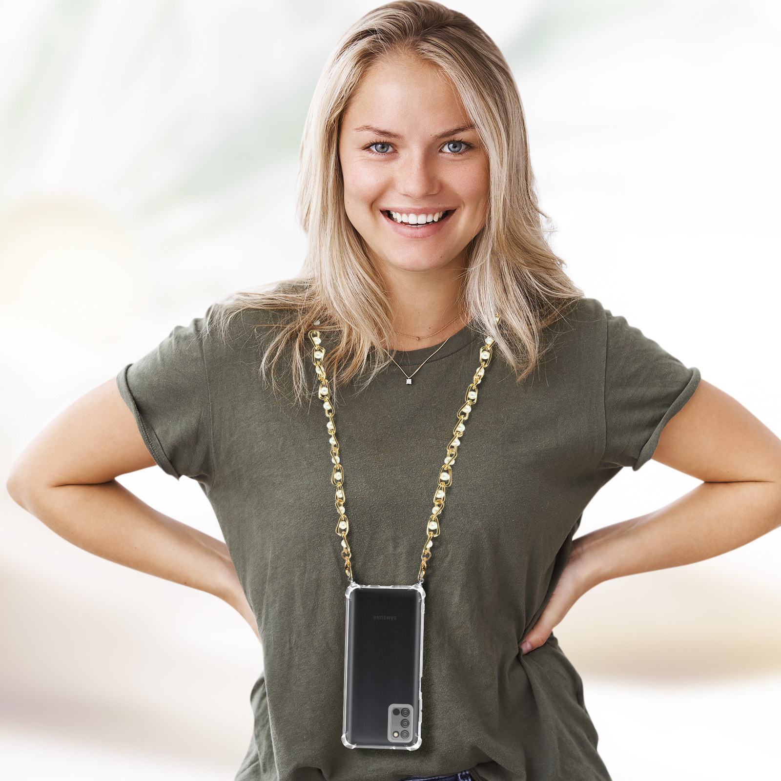 Una donna con una collana con custodia per telefono sorride, la collana è una catena d'oro.