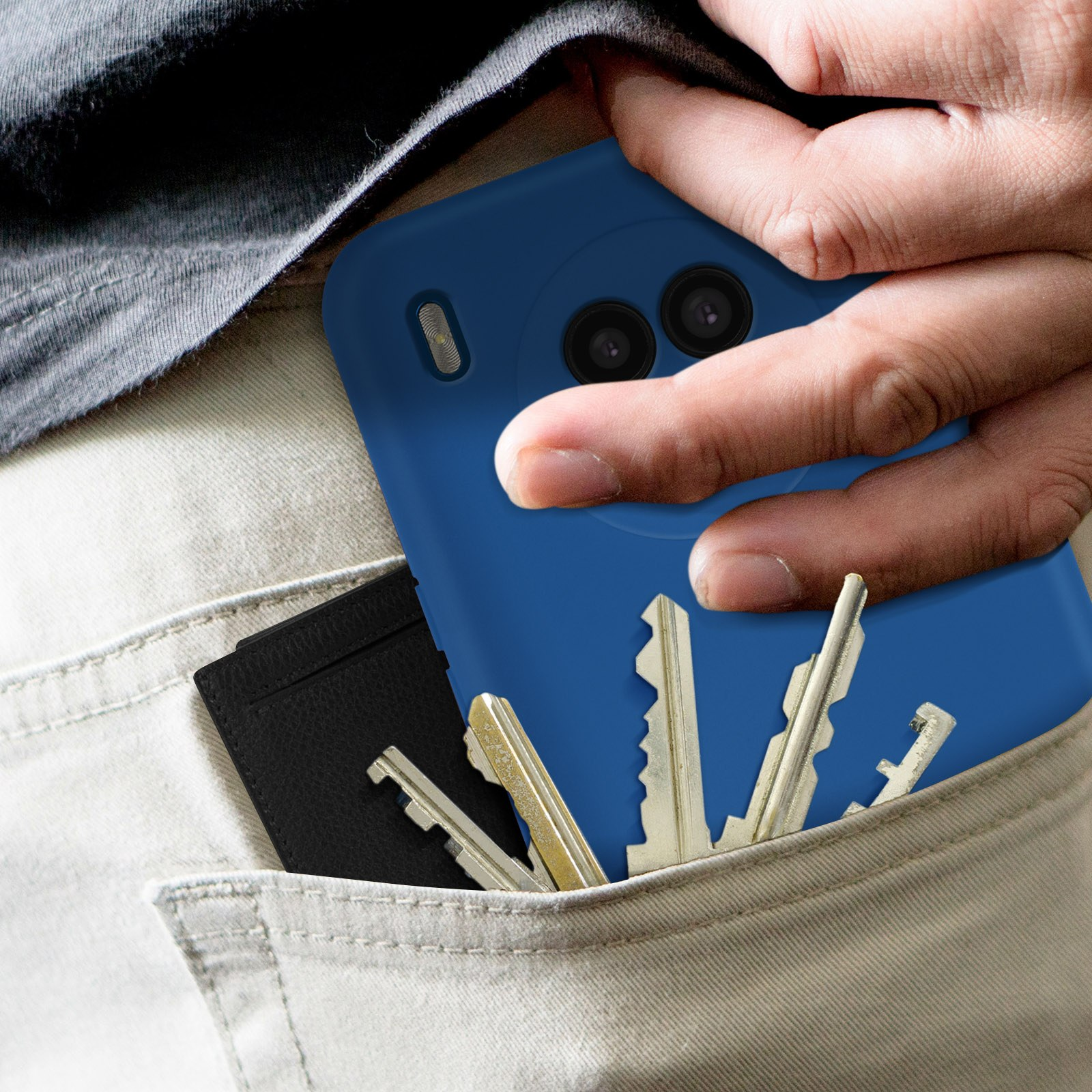 Main dans la poche avec coque de téléphone bleue et clés, coque bleue, clés argentées.