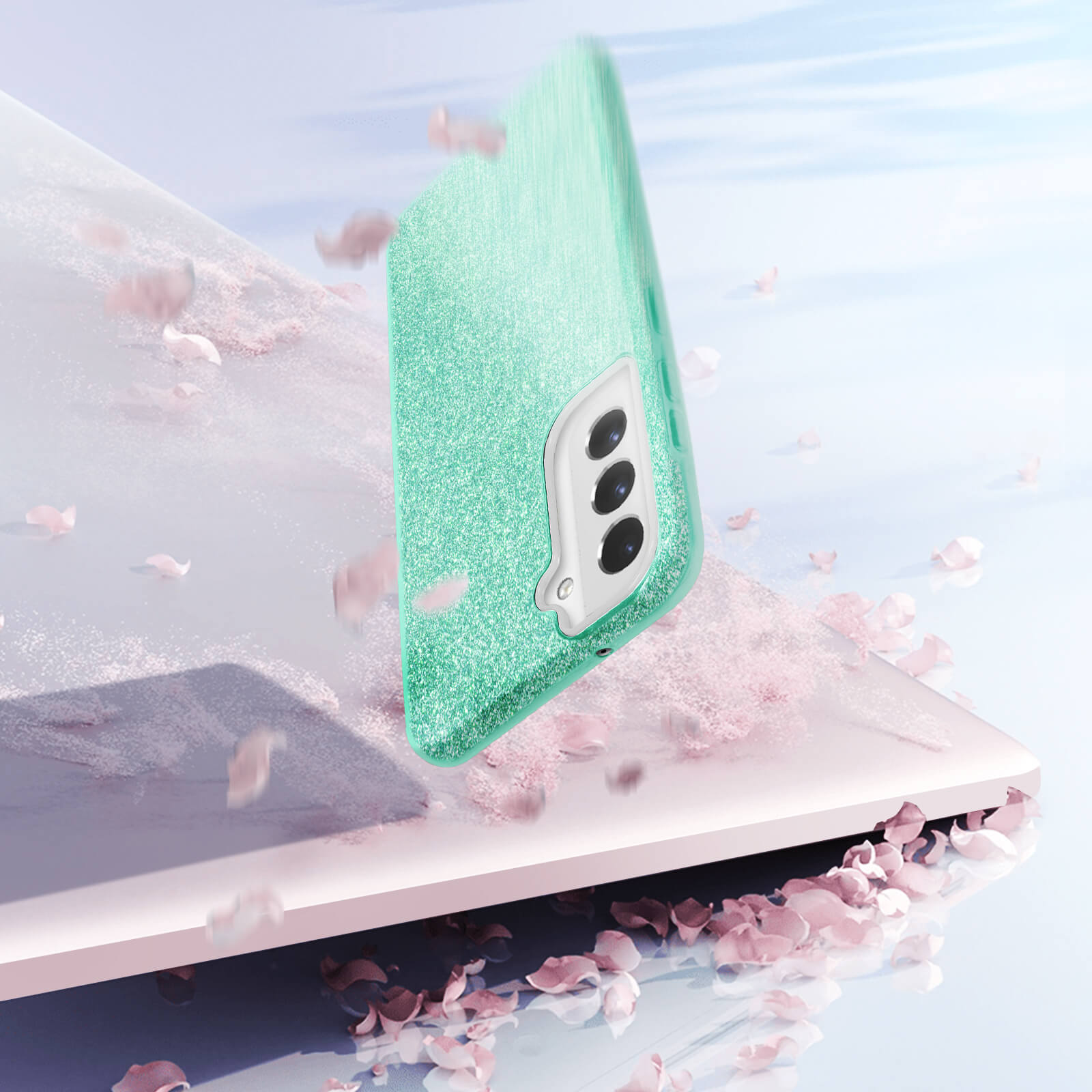 Custodia per telefono glitterata menta che cade verso una superficie, con petali di fiori.