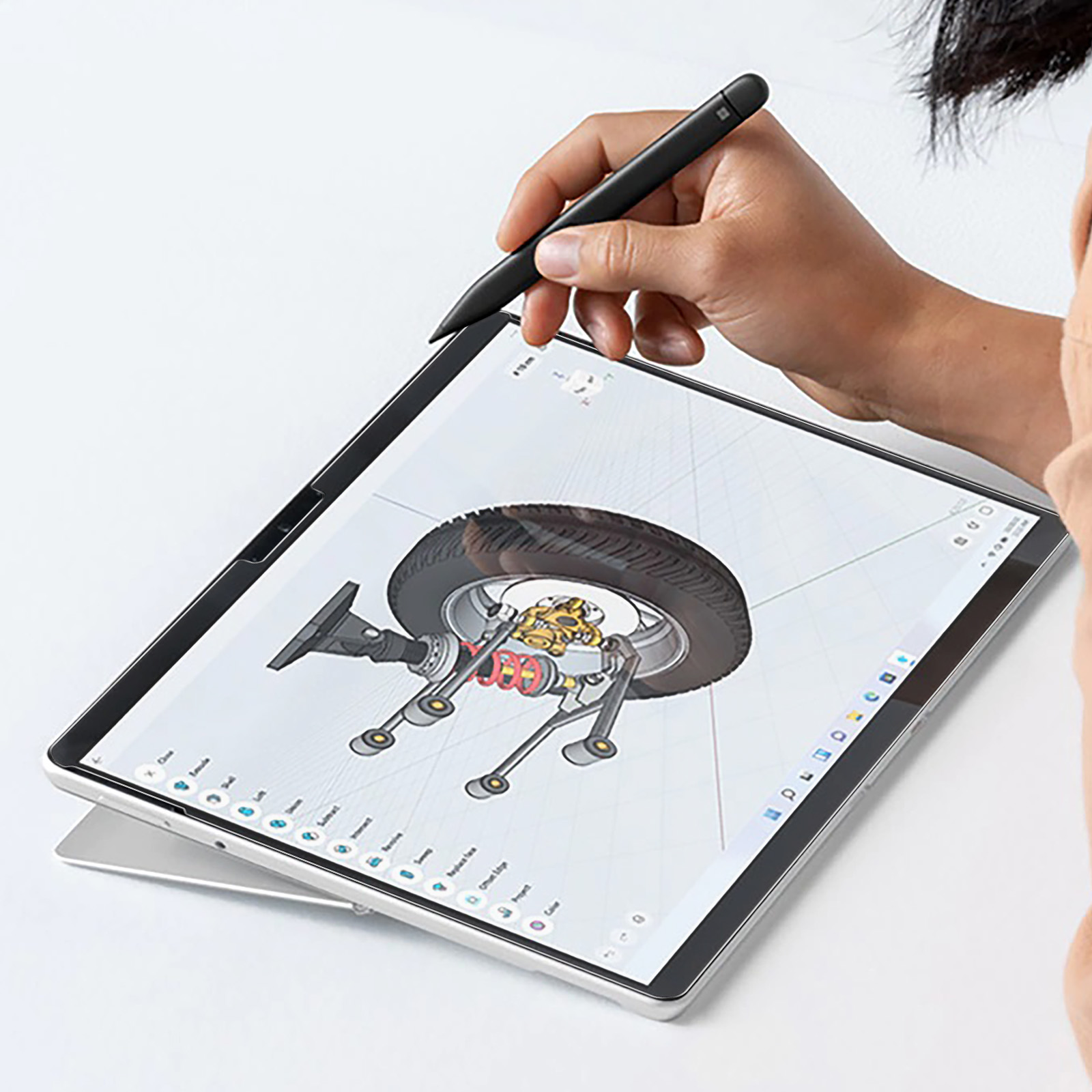 Une personne utilisant un stylet sur une tablette affichant une conception de roue de voiture.