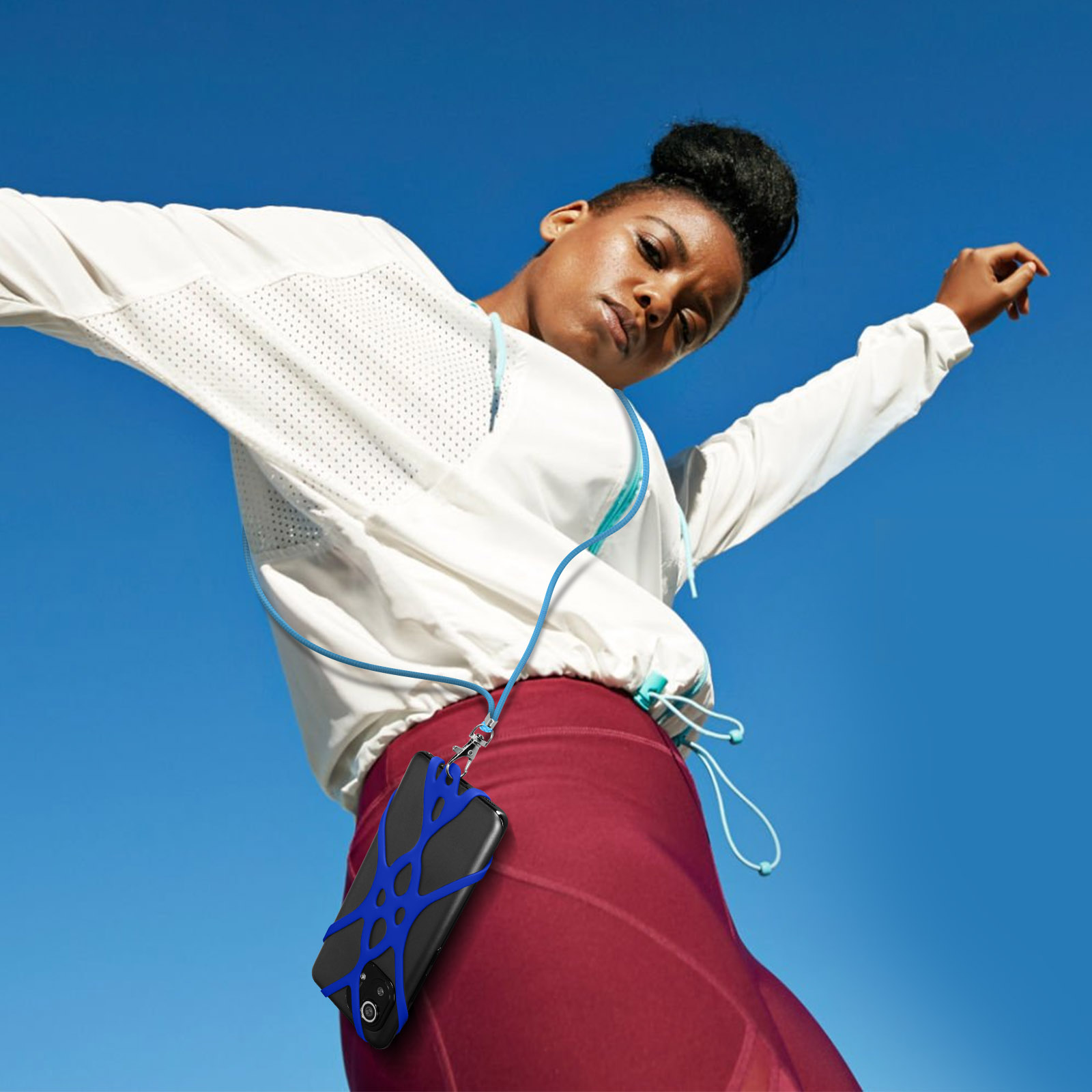 Donna in abbigliamento sportivo con laccetto per telefono cielo blu.
