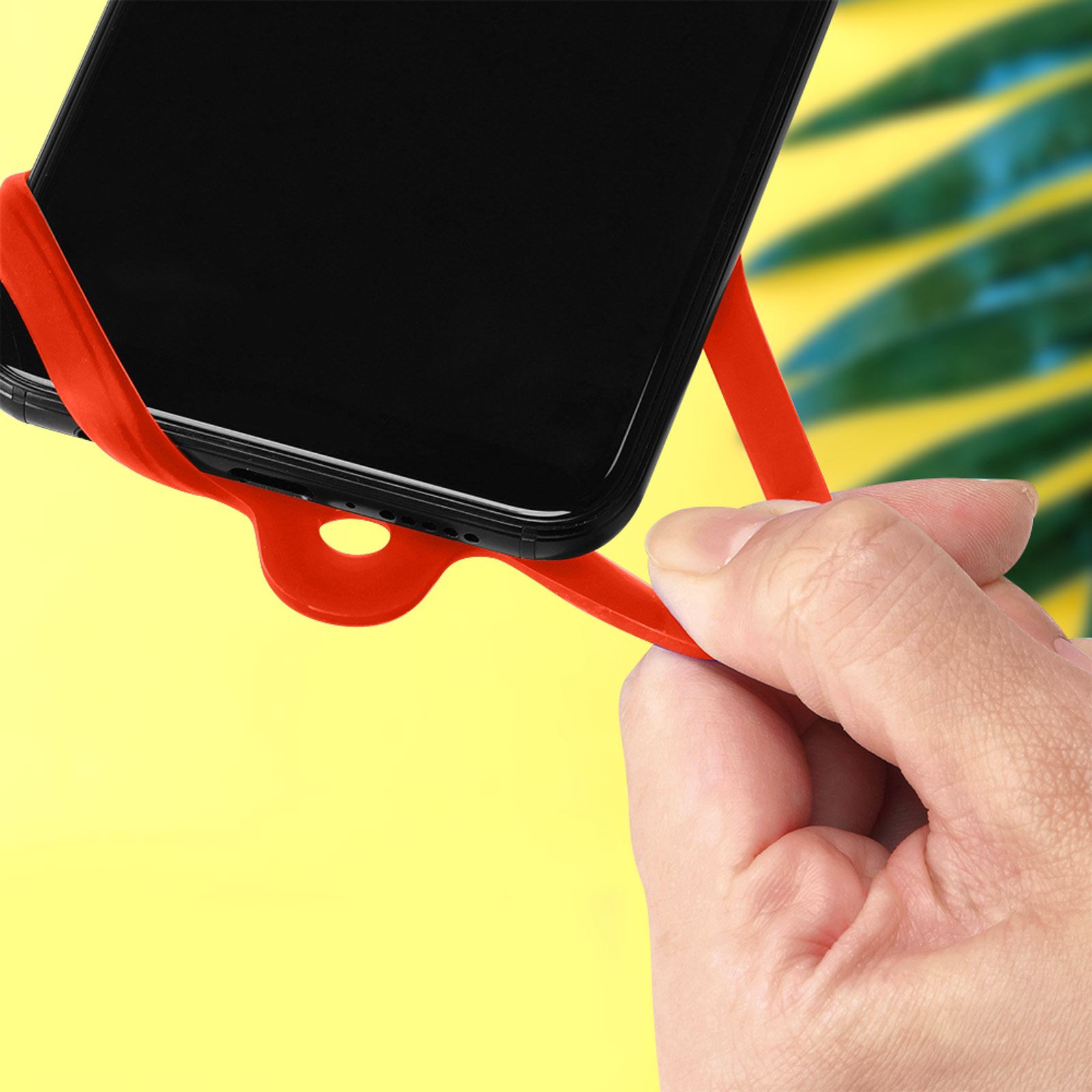 Un supporto rosso per telefono su sfondo giallo, che tiene un telefono nero.