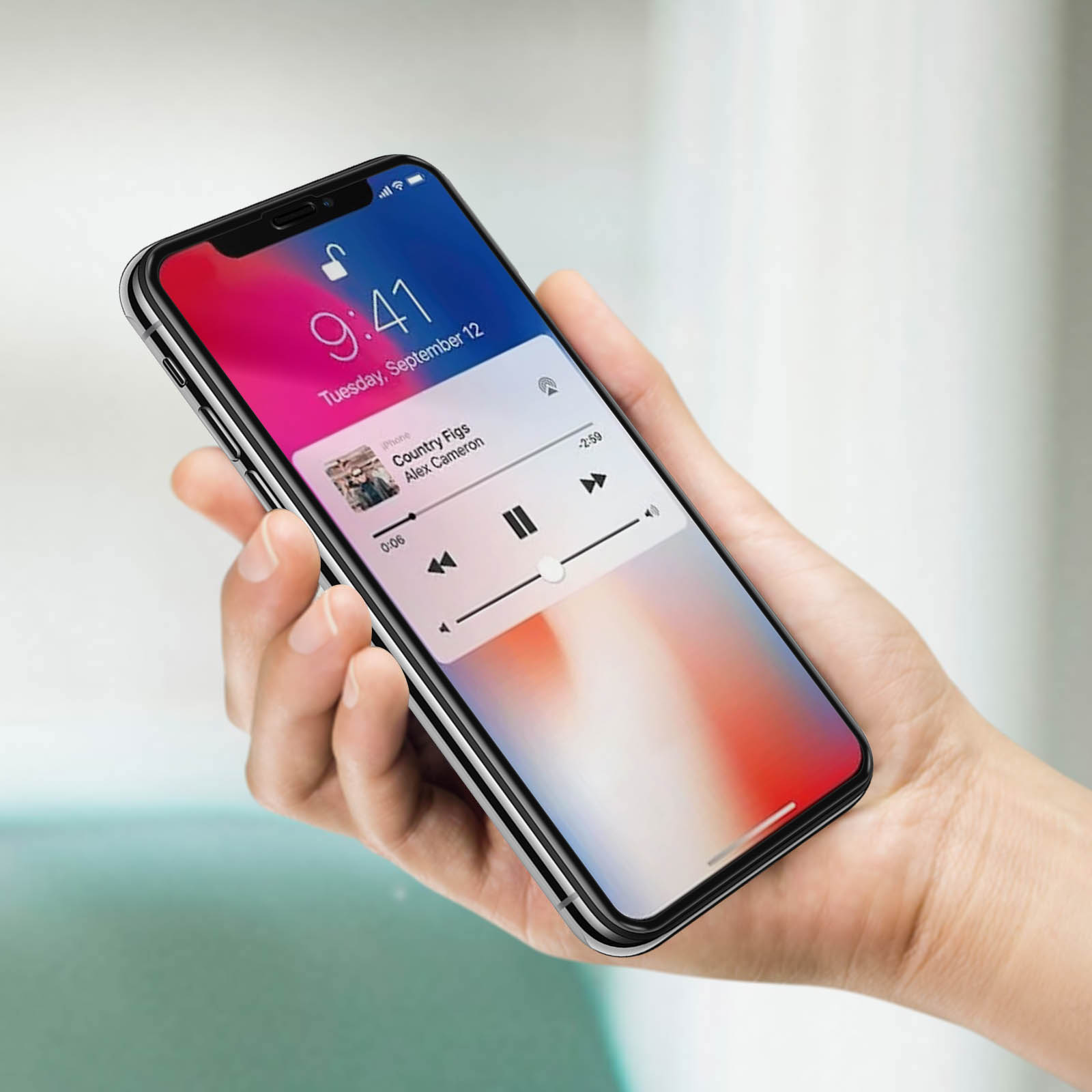 Mano che tiene un telefono. Musica in riproduzione. Il display mostra la canzone e i controlli. Sfondo sfocato.